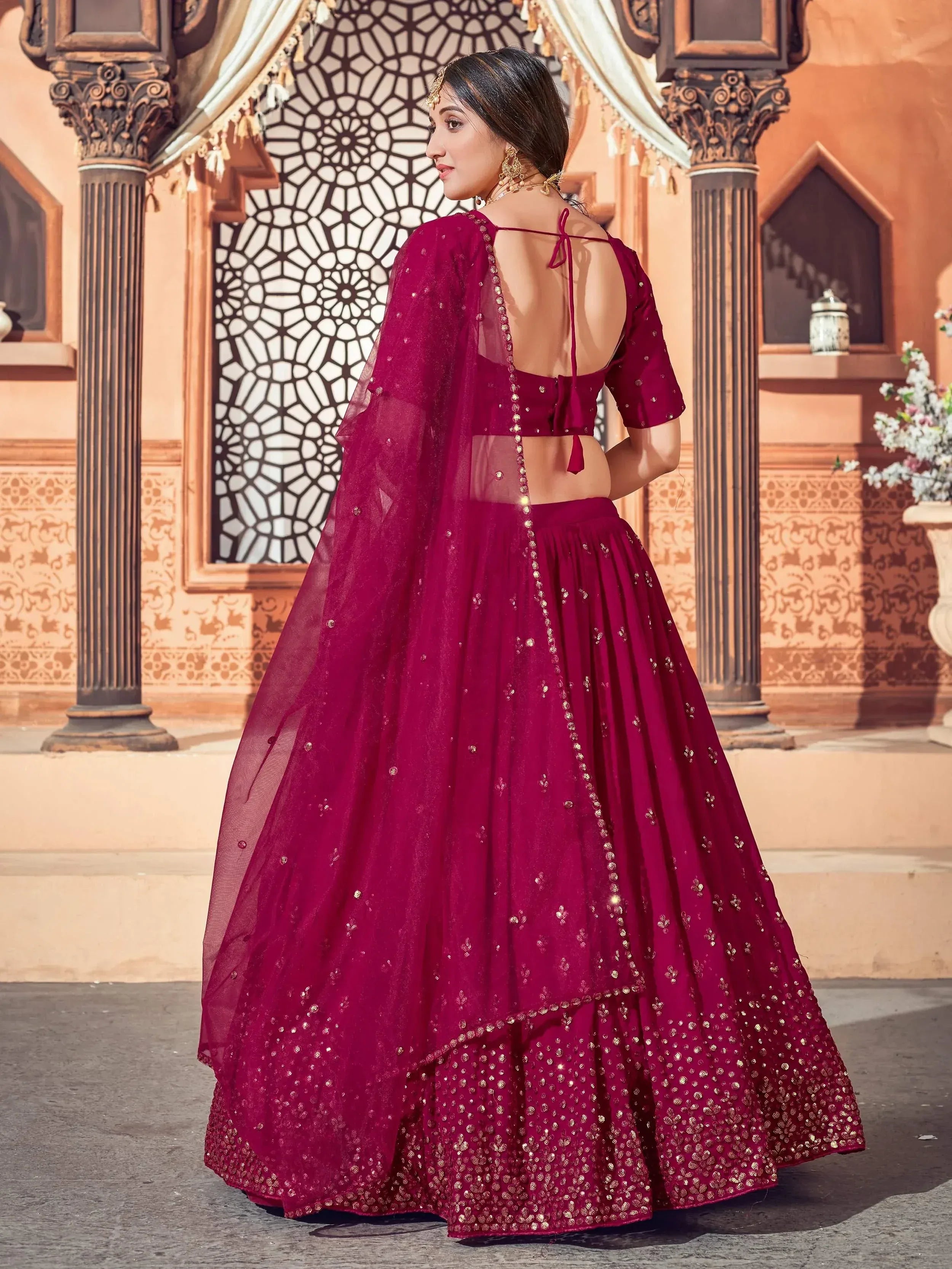 Elegant maroon lehenga choli with gold embroidery, backless blouse, and sheer dupatta for Indian ethnic wear