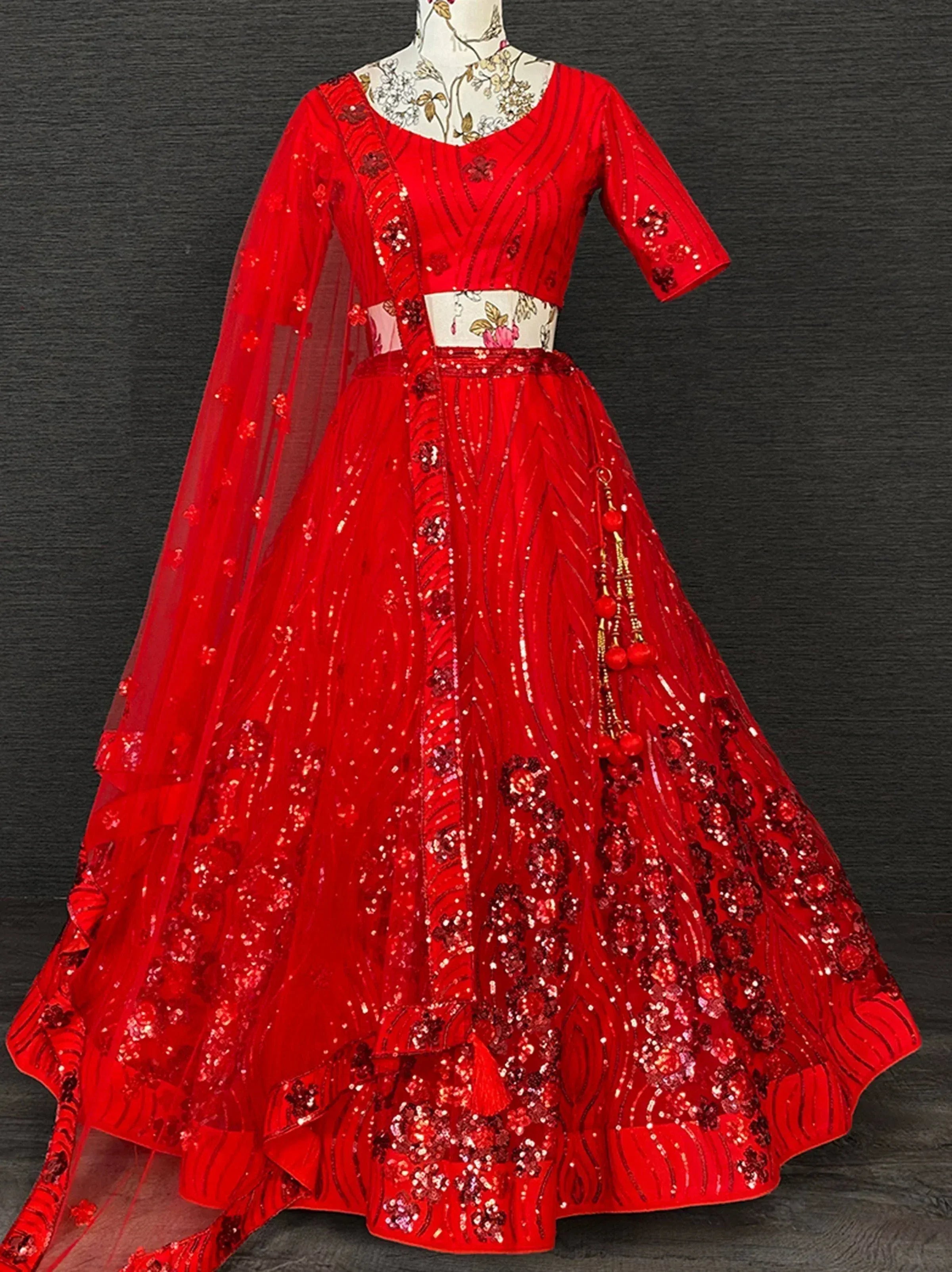 Red sequined lehenga choli with floral embroidery and sheer dupatta, ideal for Indian ethnic occasions