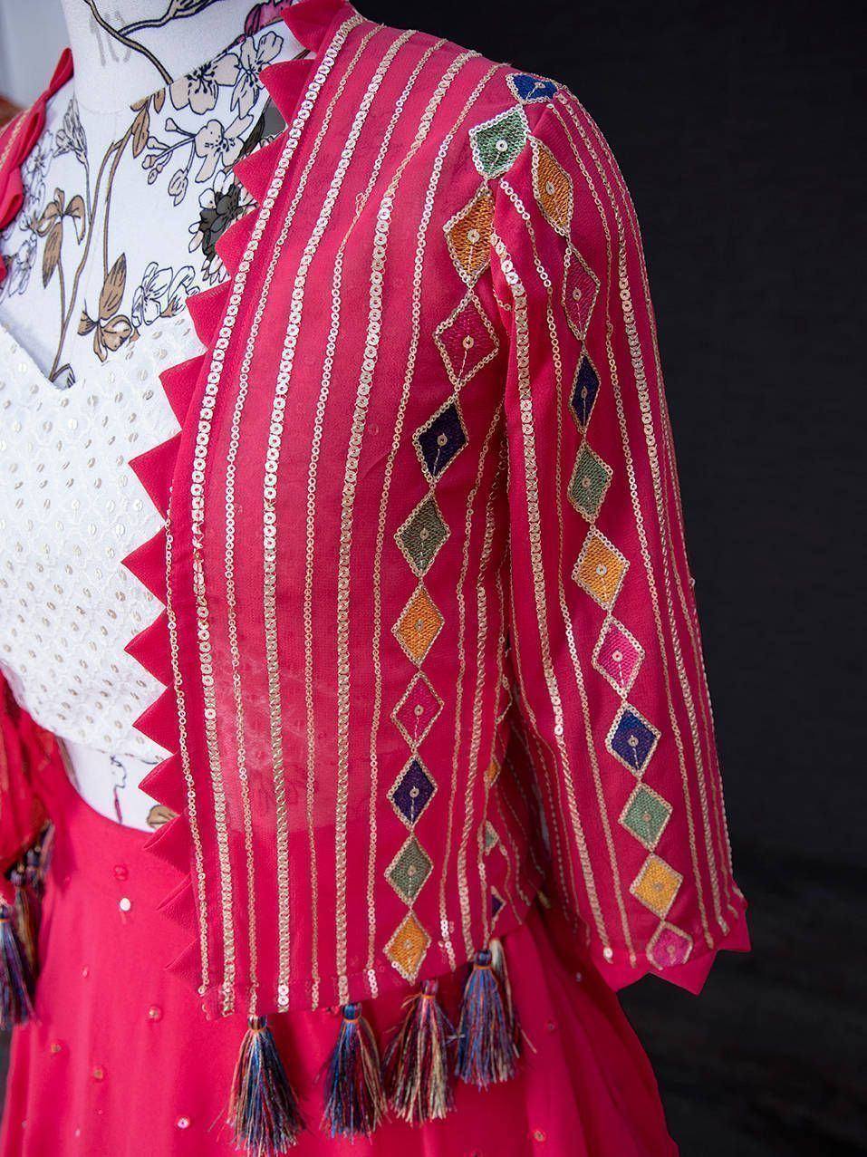 Pink ethnic jacket with sequin stripes, diamond embroidery, and tassels, styled with floral top