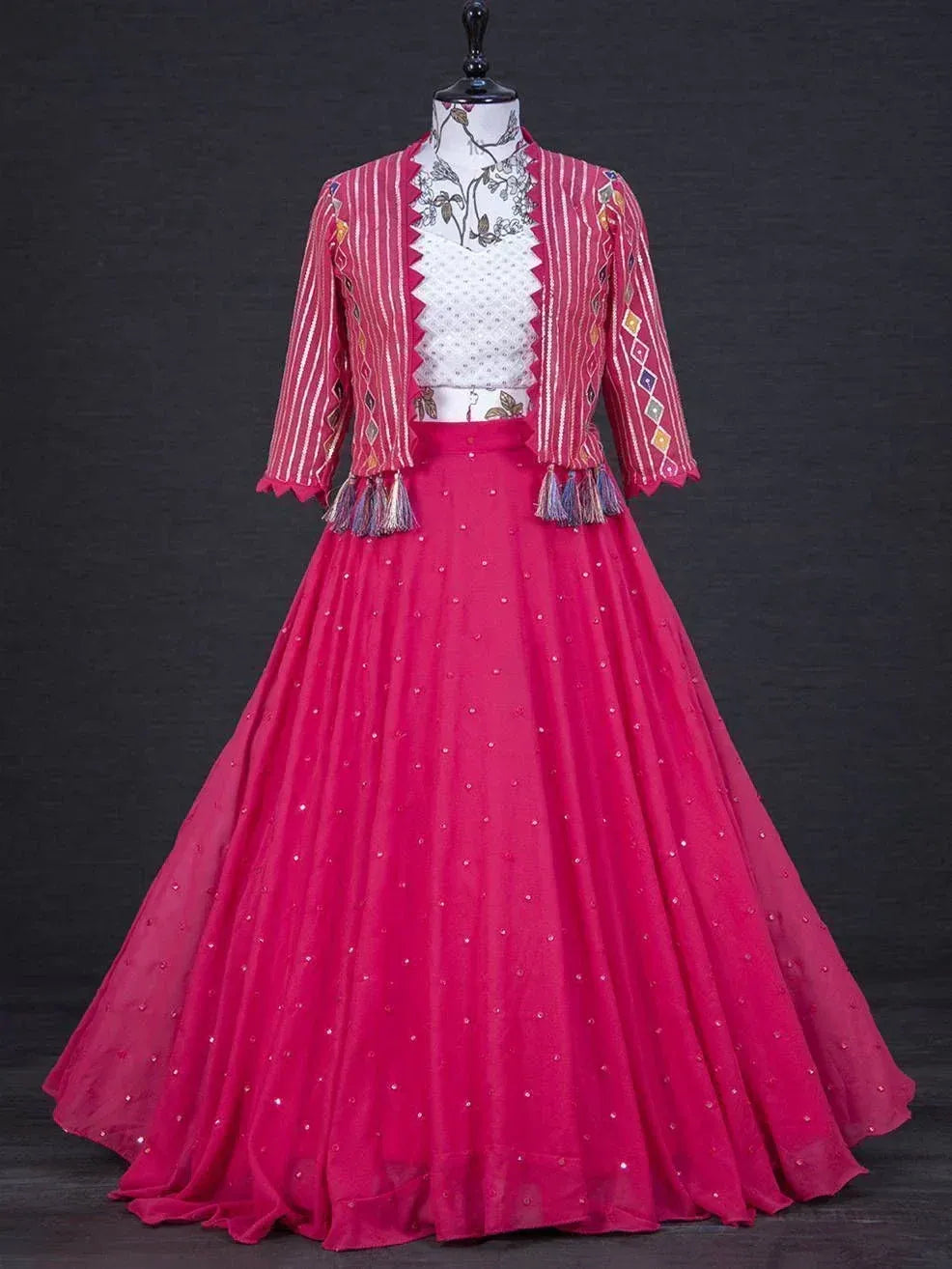 Pink ethnic lehenga choli with embroidered jacket and tassels, perfect for Indian weddings and festive occasions.