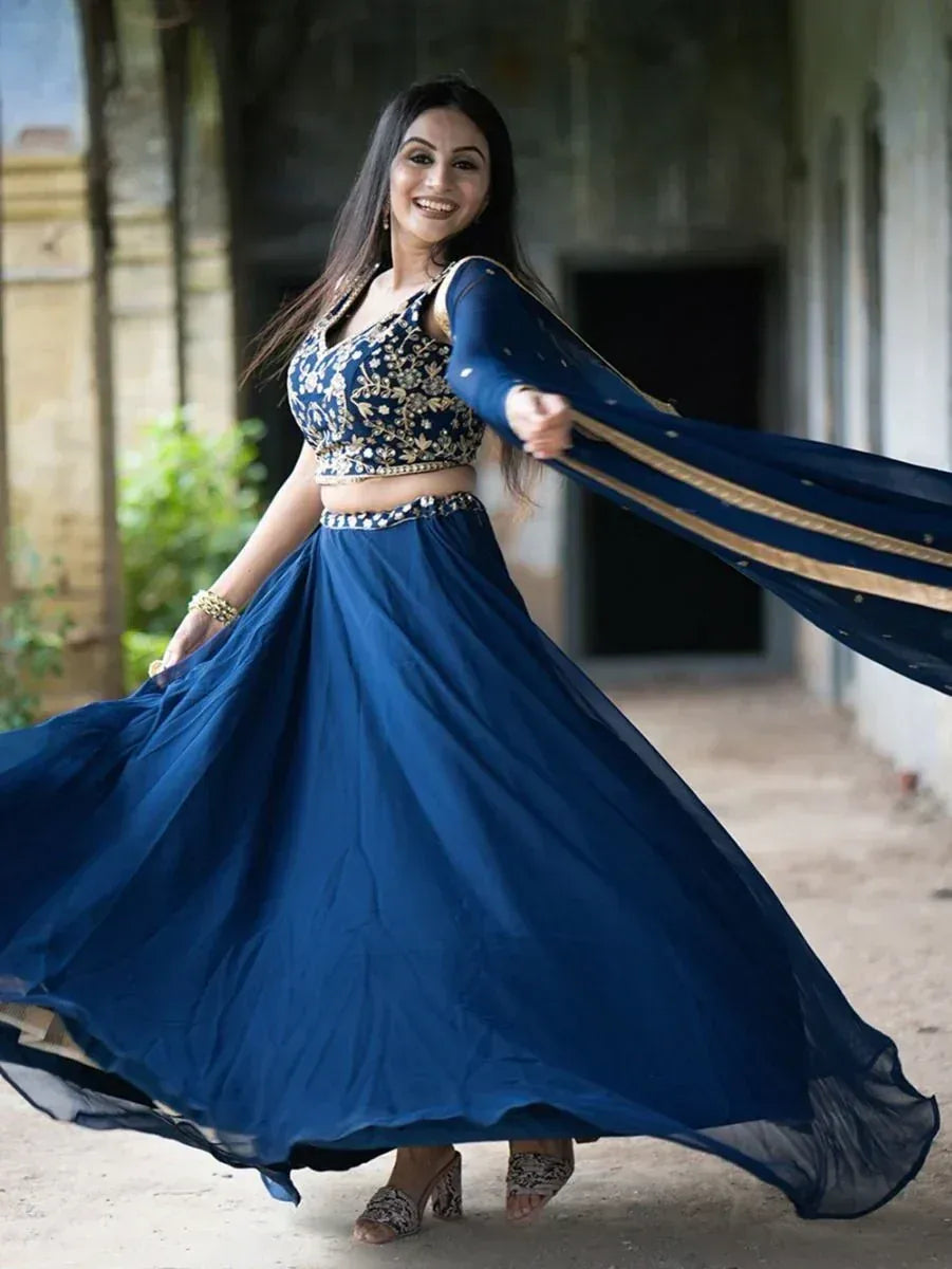 Woman in navy blue embroidered lehenga choli with flowing dupatta, perfect for Indian ethnic occasions