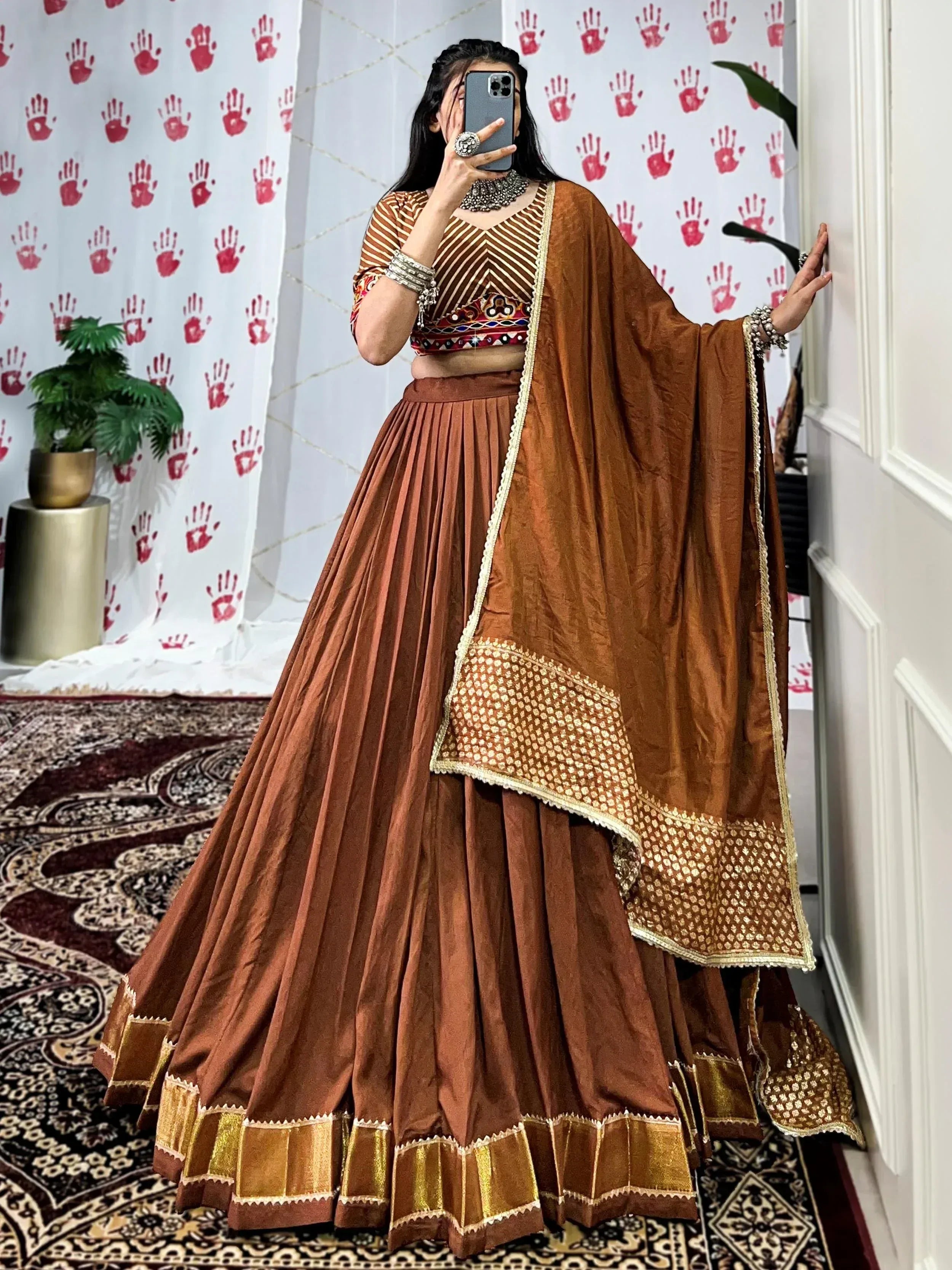 Brown ethnic lehenga choli with gold embroidery, pleated skirt, and dupatta for Indian wear