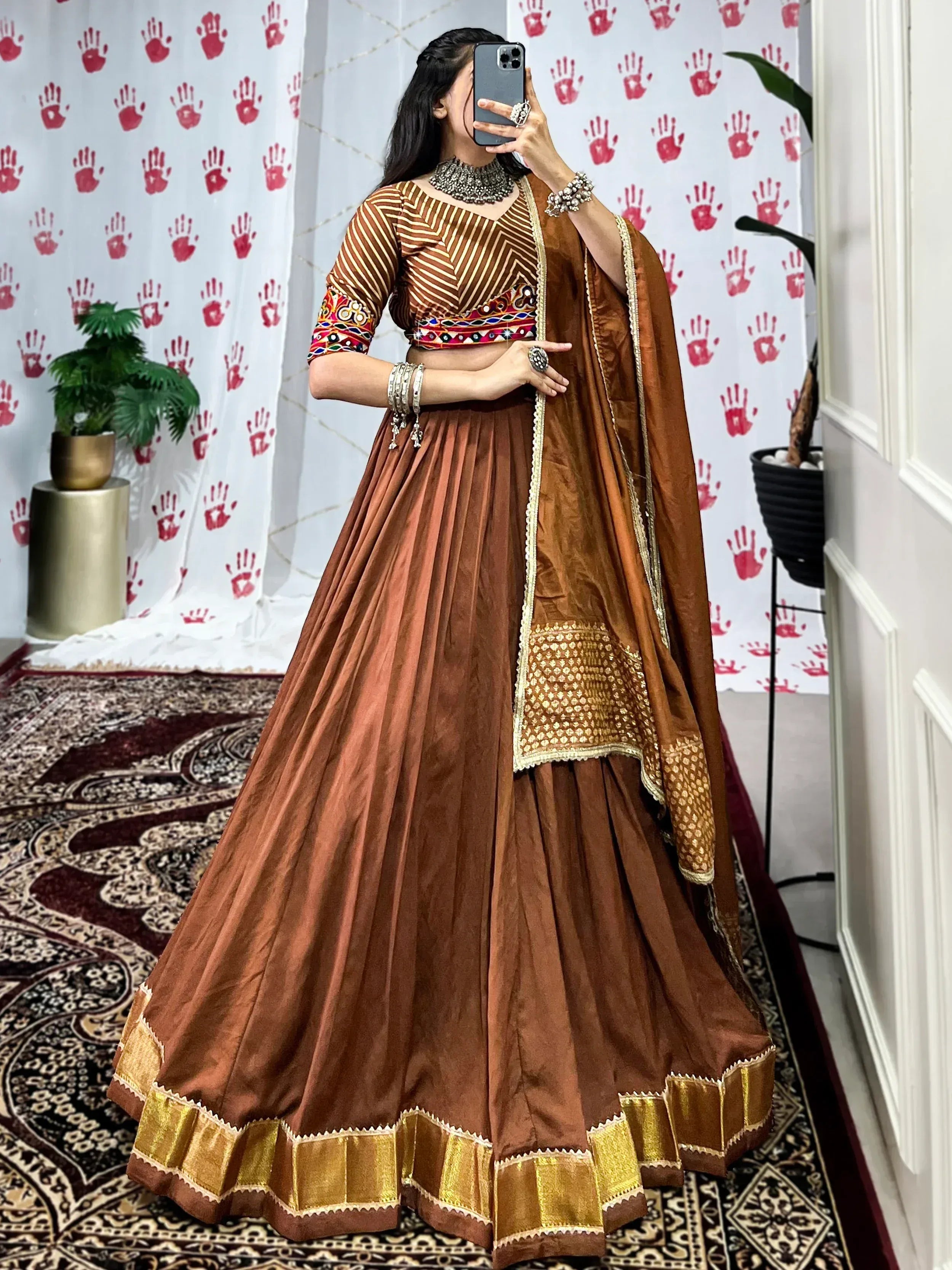 Brown designer lehenga choli with gold trim and mirror work, perfect for Indian ethnic wear occasions.