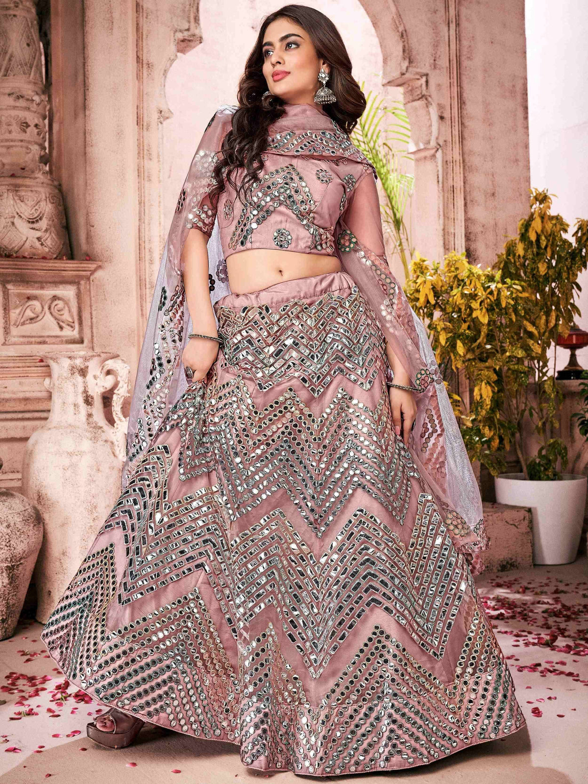 Dusty pink designer lehenga choli with mirror work and sheer dupatta, perfect for Indian weddings and festive occasions.