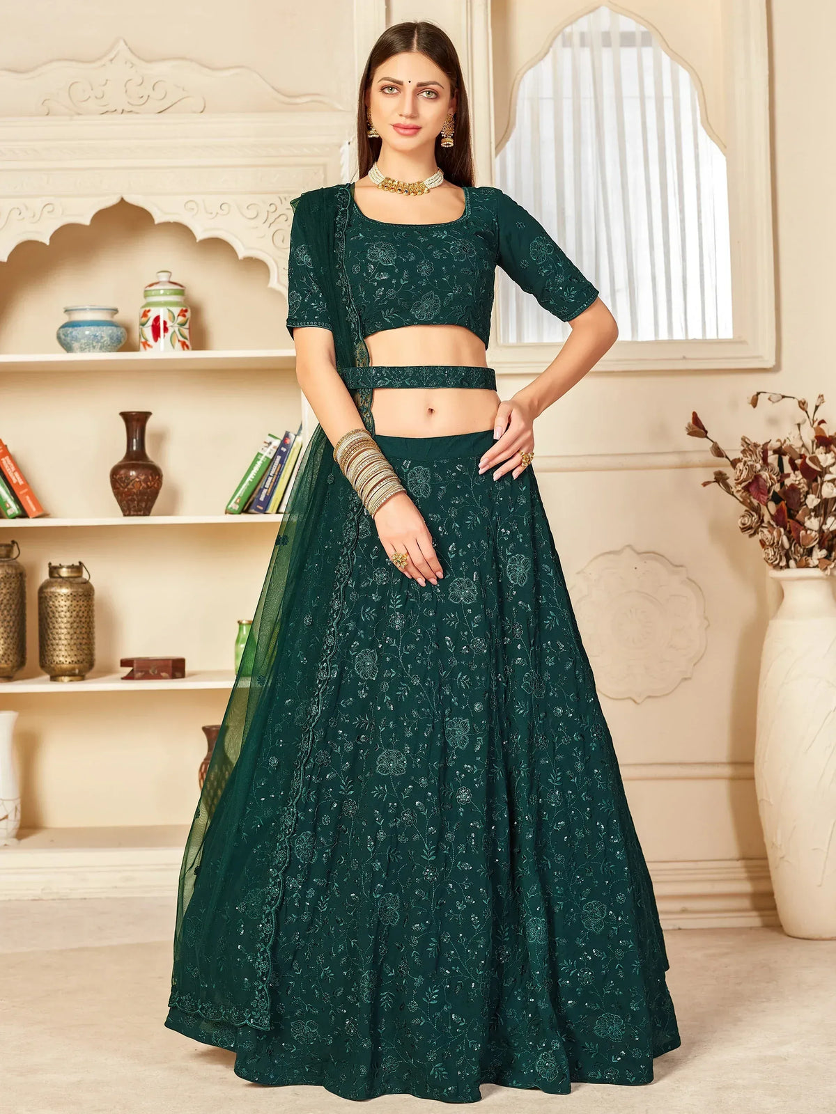 Emerald green embroidered lehenga choli with floral designs and gold jewelry