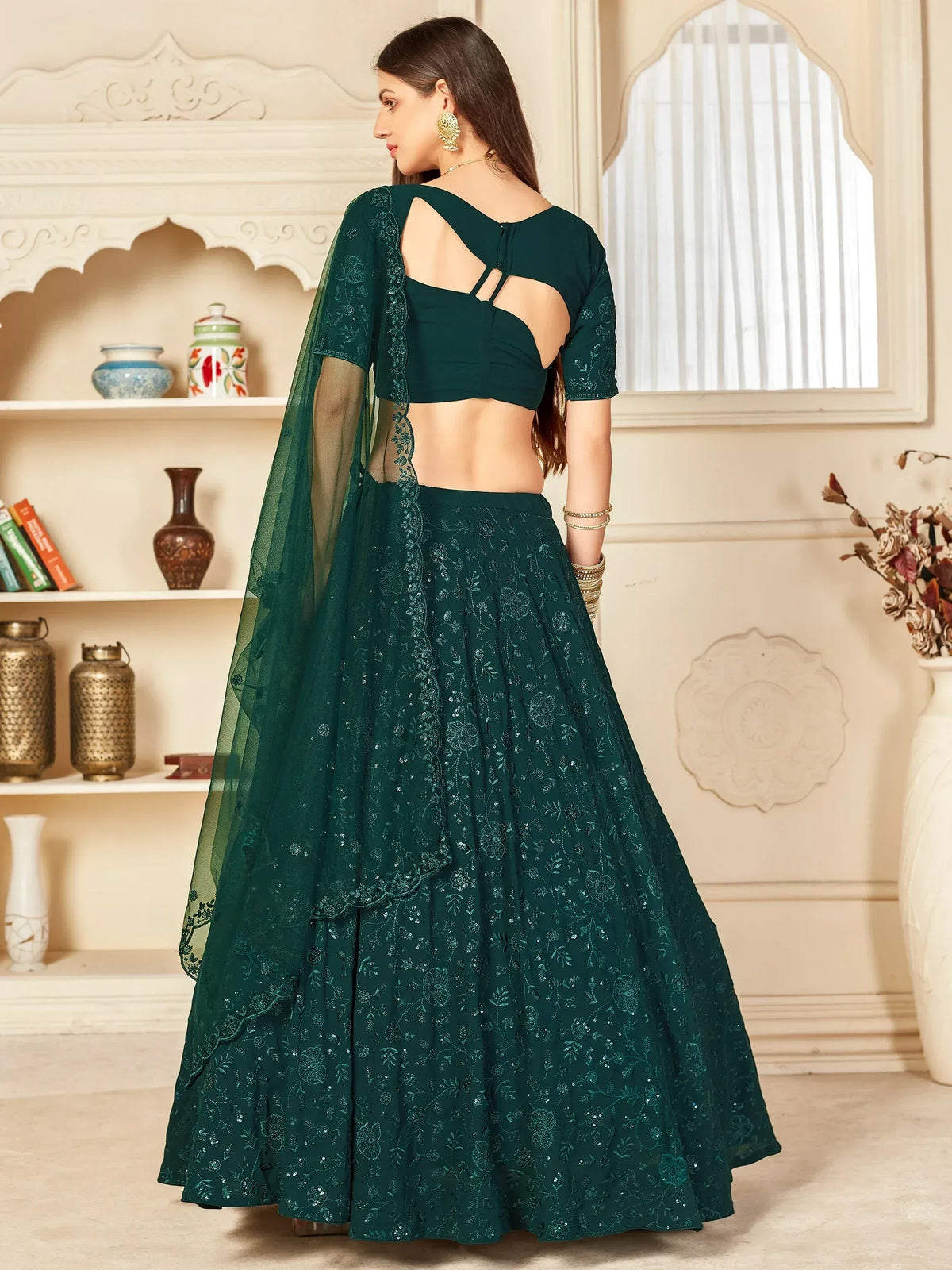 Emerald green embroidered lehenga choli with back cutout design, perfect for Indian ethnic wear