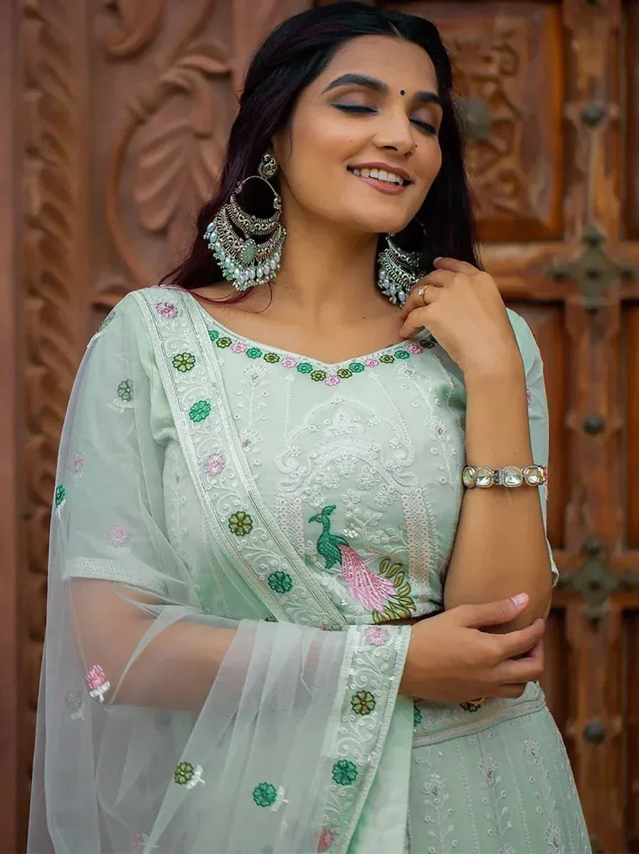 Mint green embroidered salwar kameez with peacock design, sheer dupatta, and statement earrings