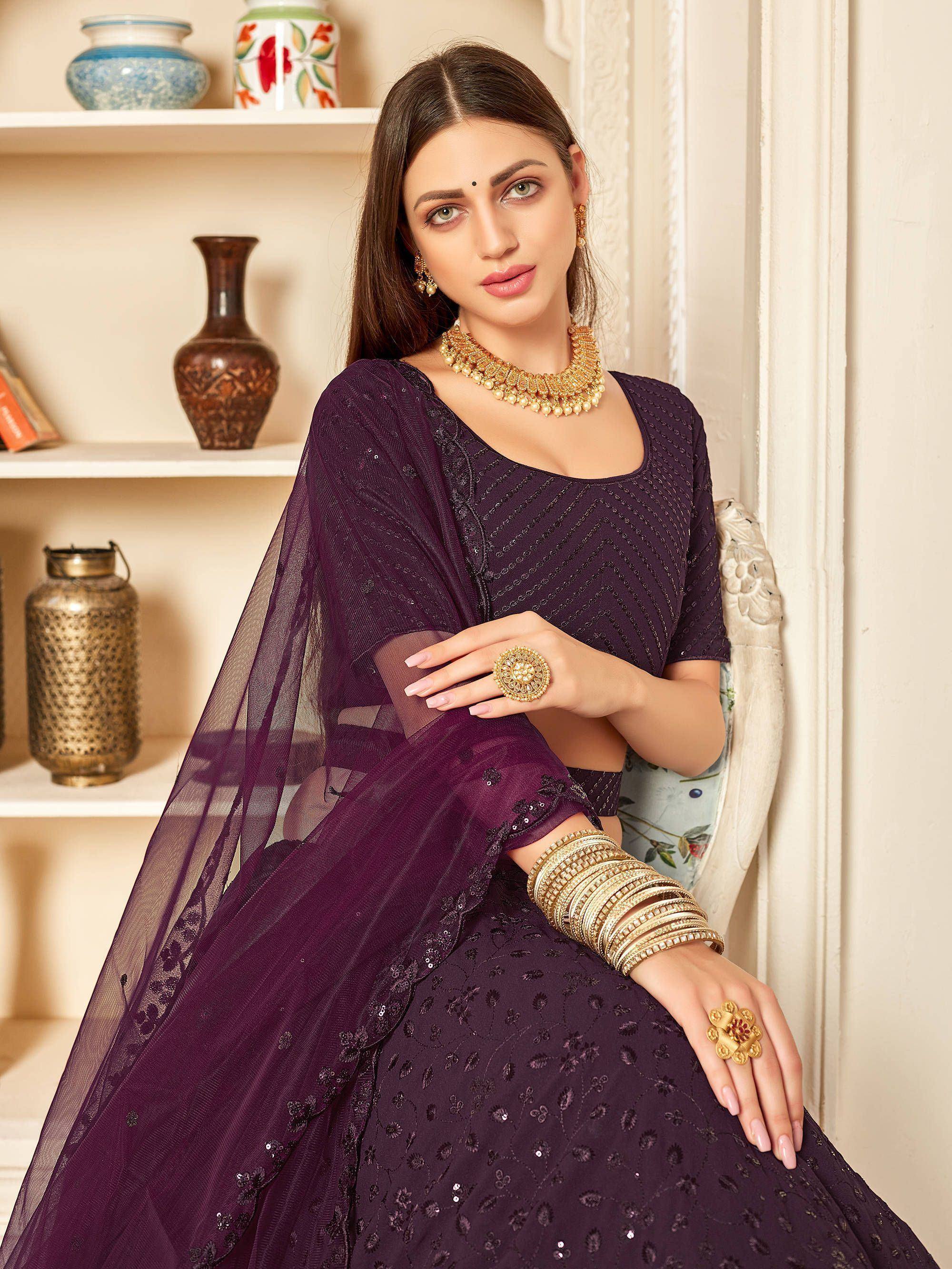 Elegant purple lehenga choli with sequin embroidery, paired with gold jewelry for festive occasions.