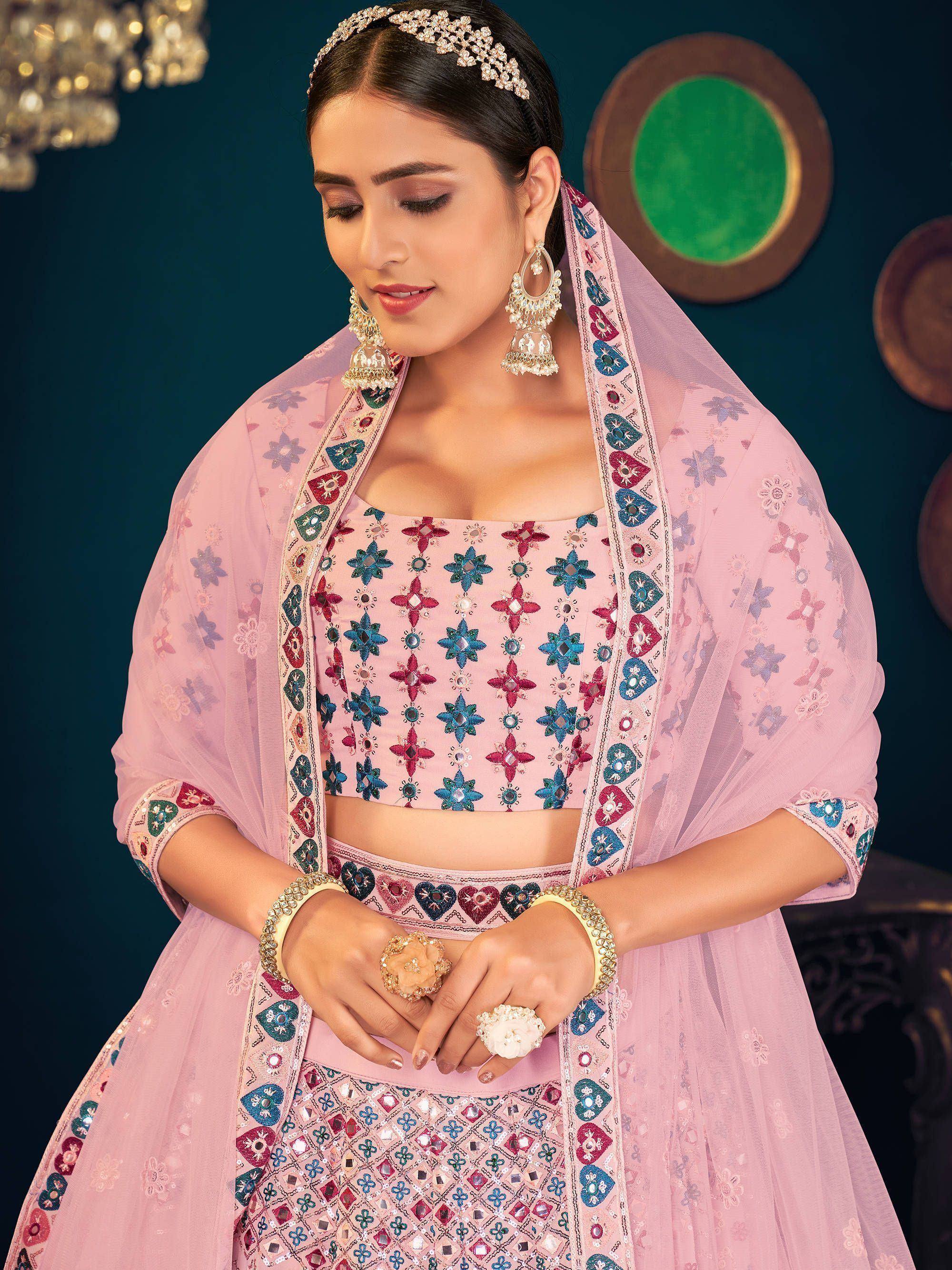 Pink embroidered lehenga choli with mirror work, floral dupatta, and traditional Indian jewelry for festive occasions