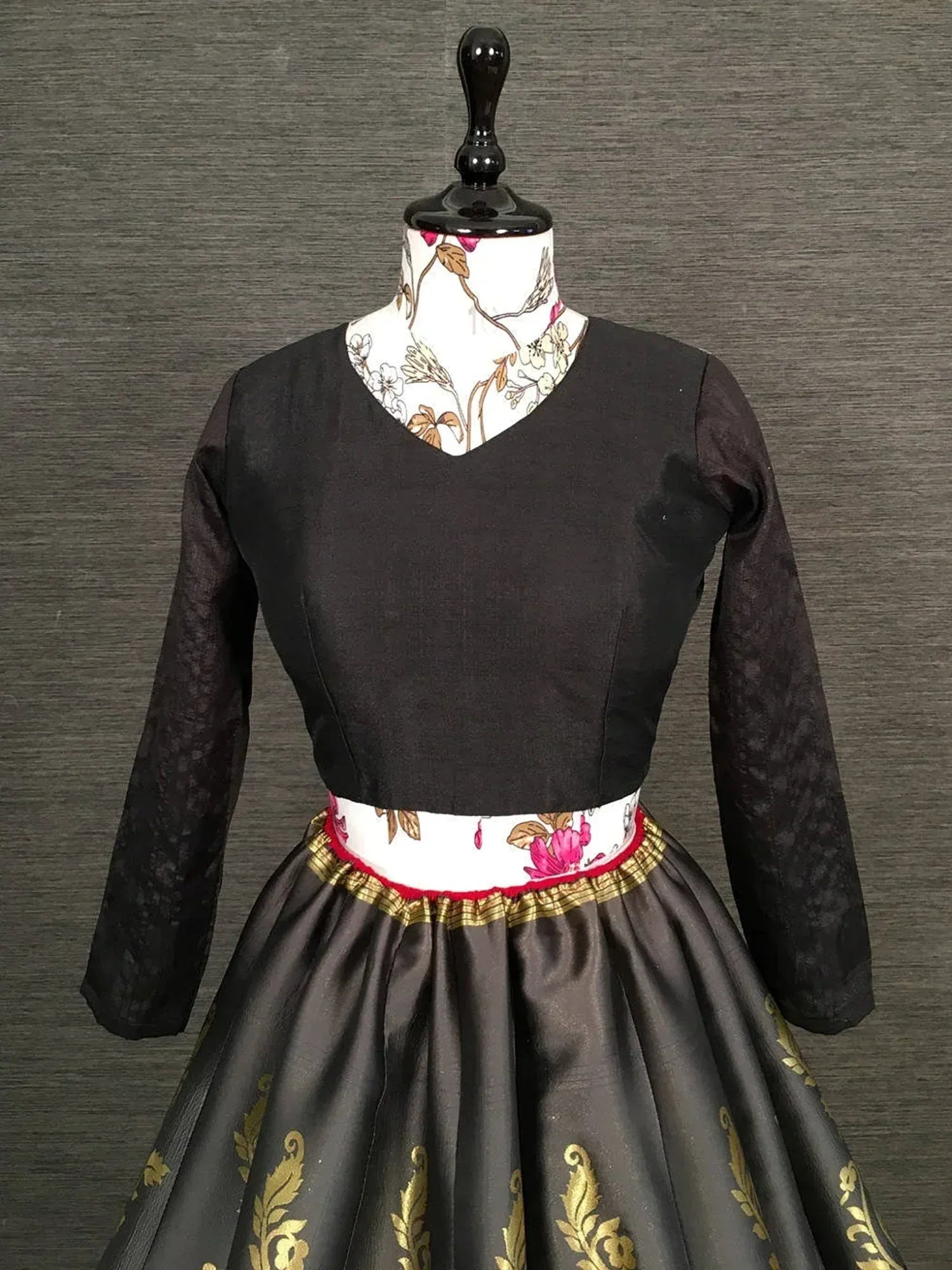 Black ethnic gown with gold embroidery and floral waistband, perfect for Indian occasions