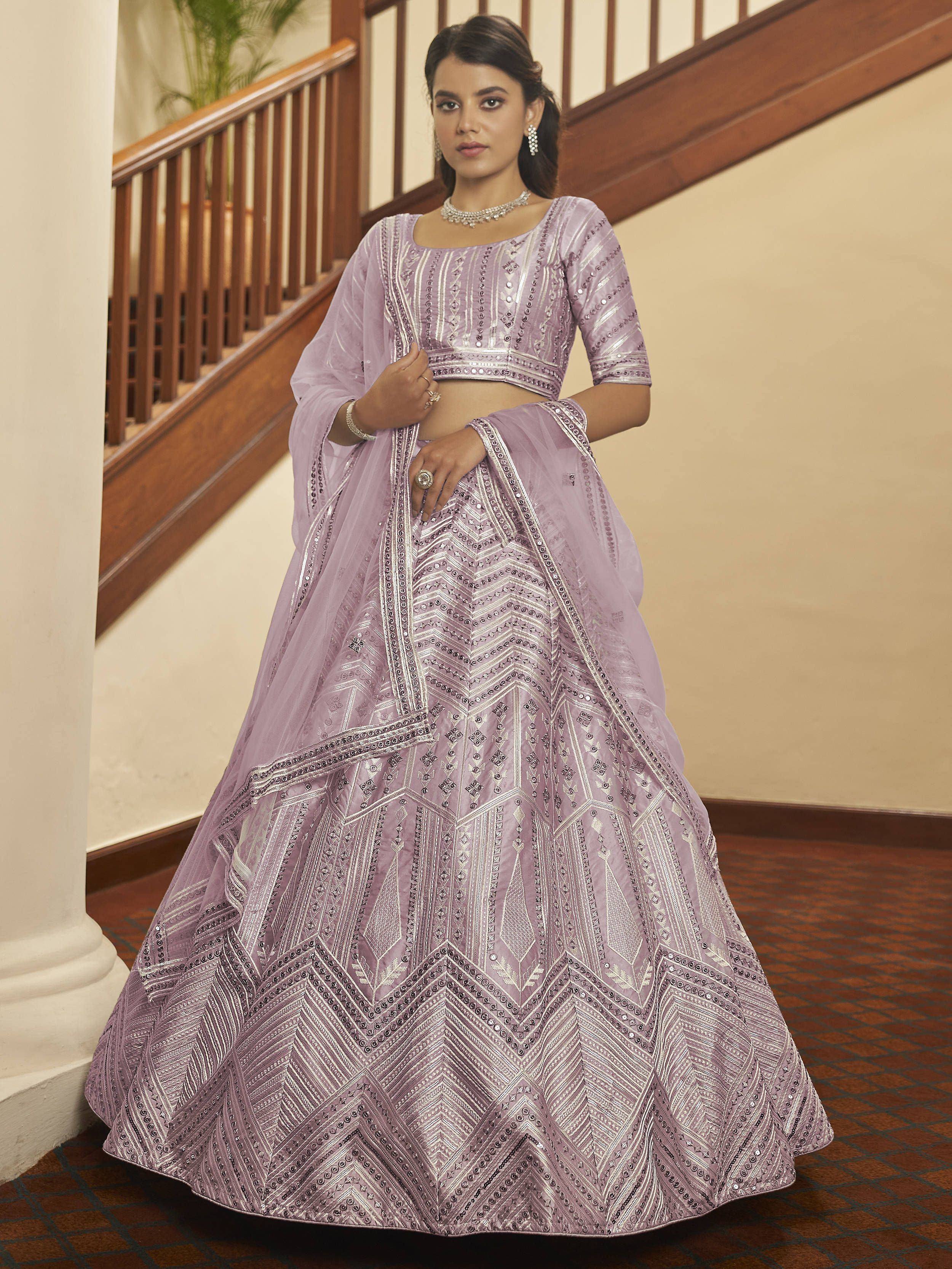 Lavender designer lehenga choli with intricate silver embroidery and mirror work, perfect for Indian weddings and festive occasions.