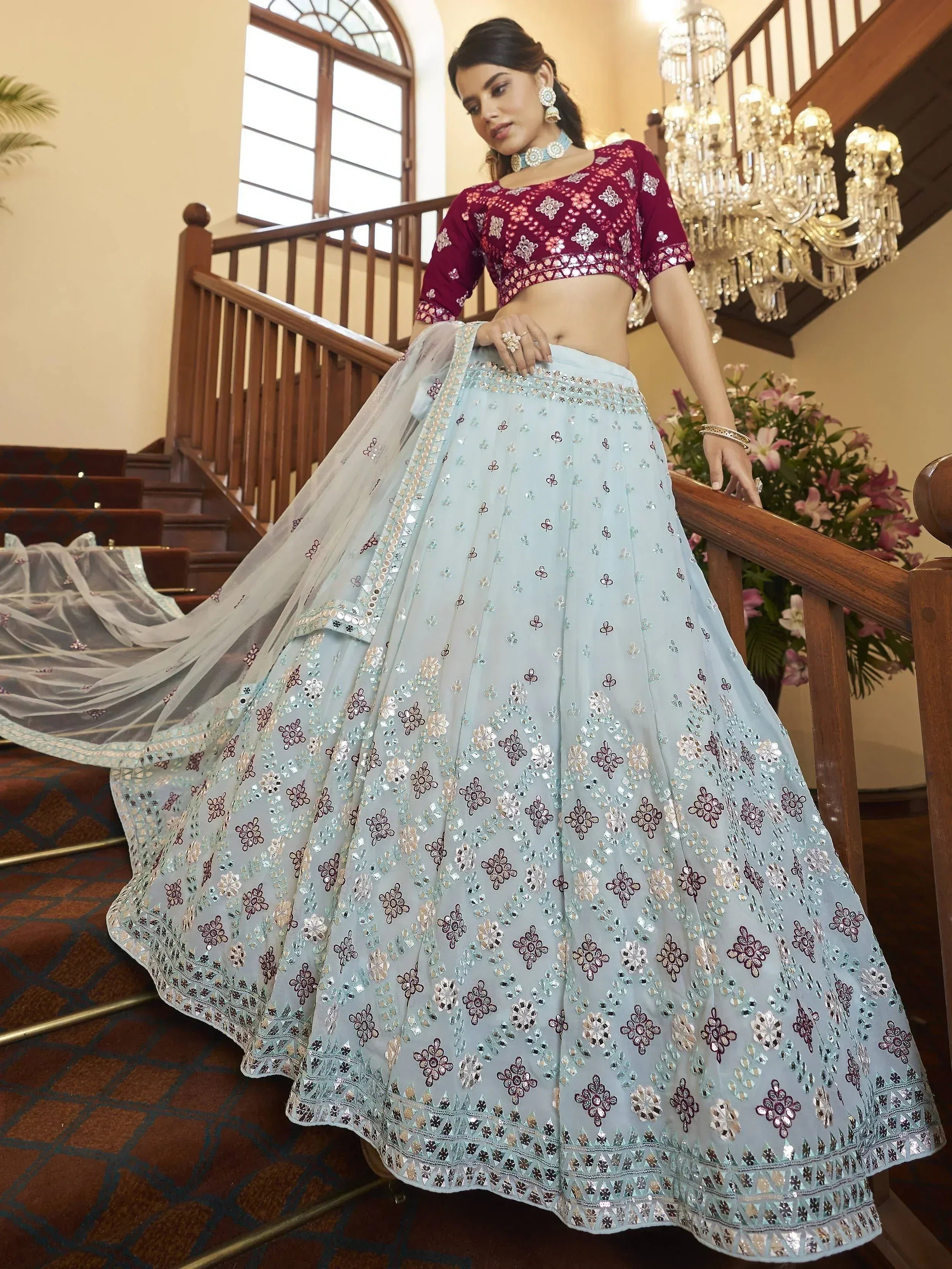 Elegant light blue lehenga choli with mirror work and maroon blouse, perfect for Indian ethnic occasions.