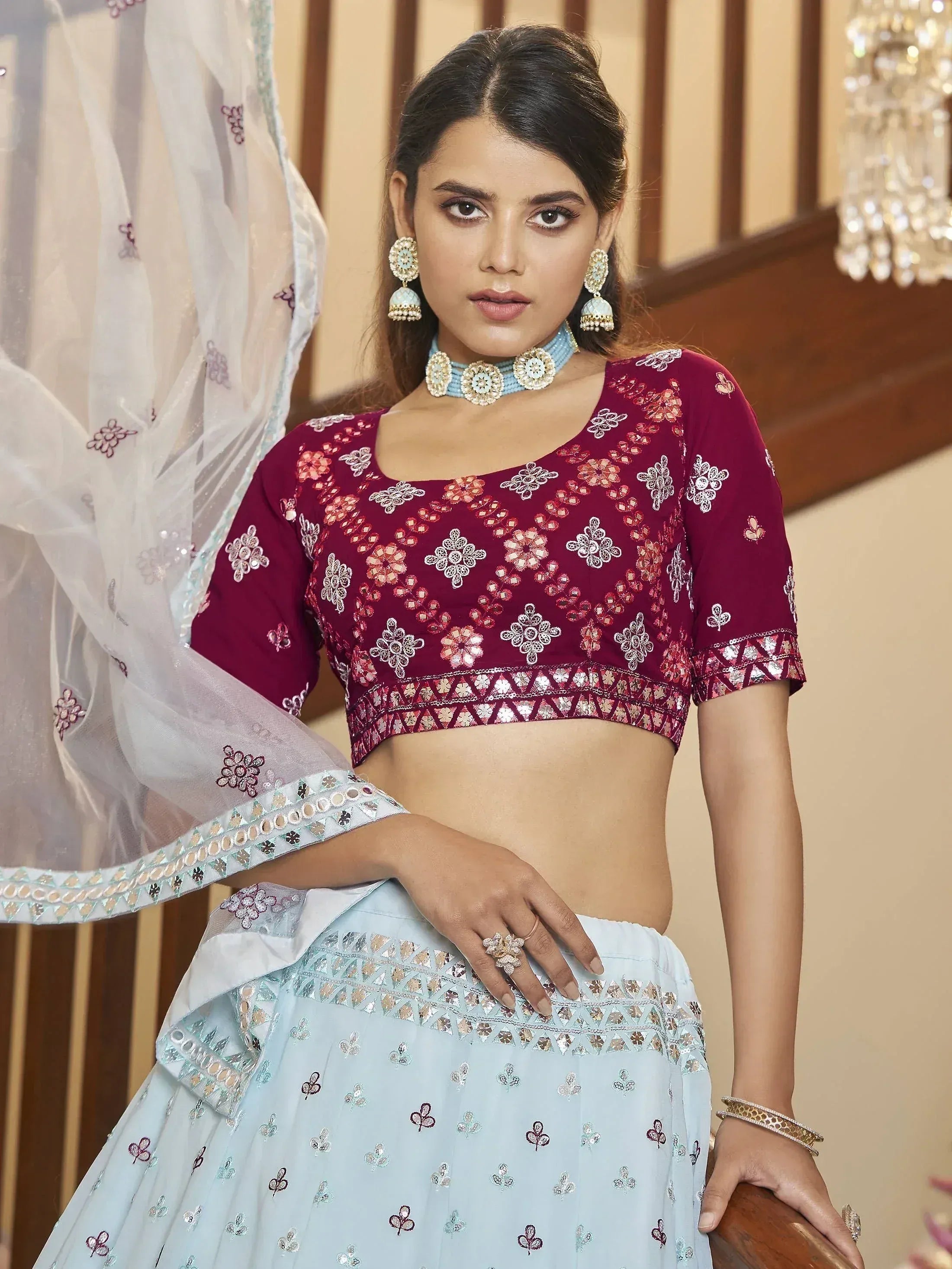 Maroon and sky blue embroidered lehenga choli with floral motifs and mirror work, perfect for Indian ethnic wear.