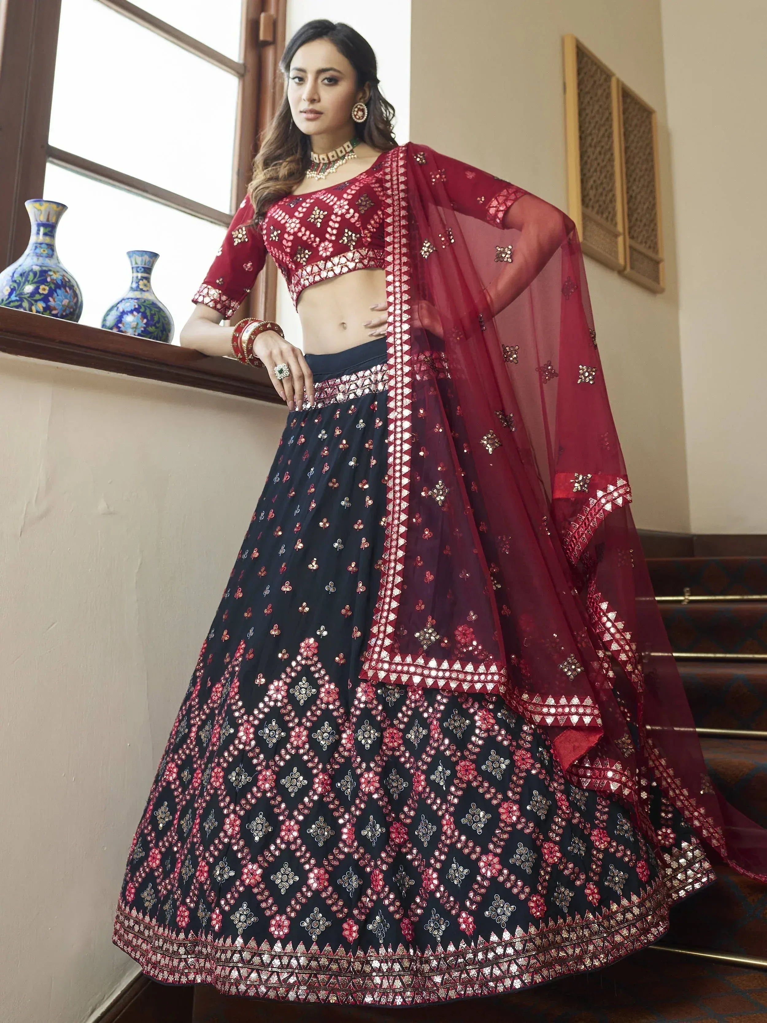 Maroon and navy blue embroidered lehenga choli with mirror work, perfect for Indian ethnic wear occasions.