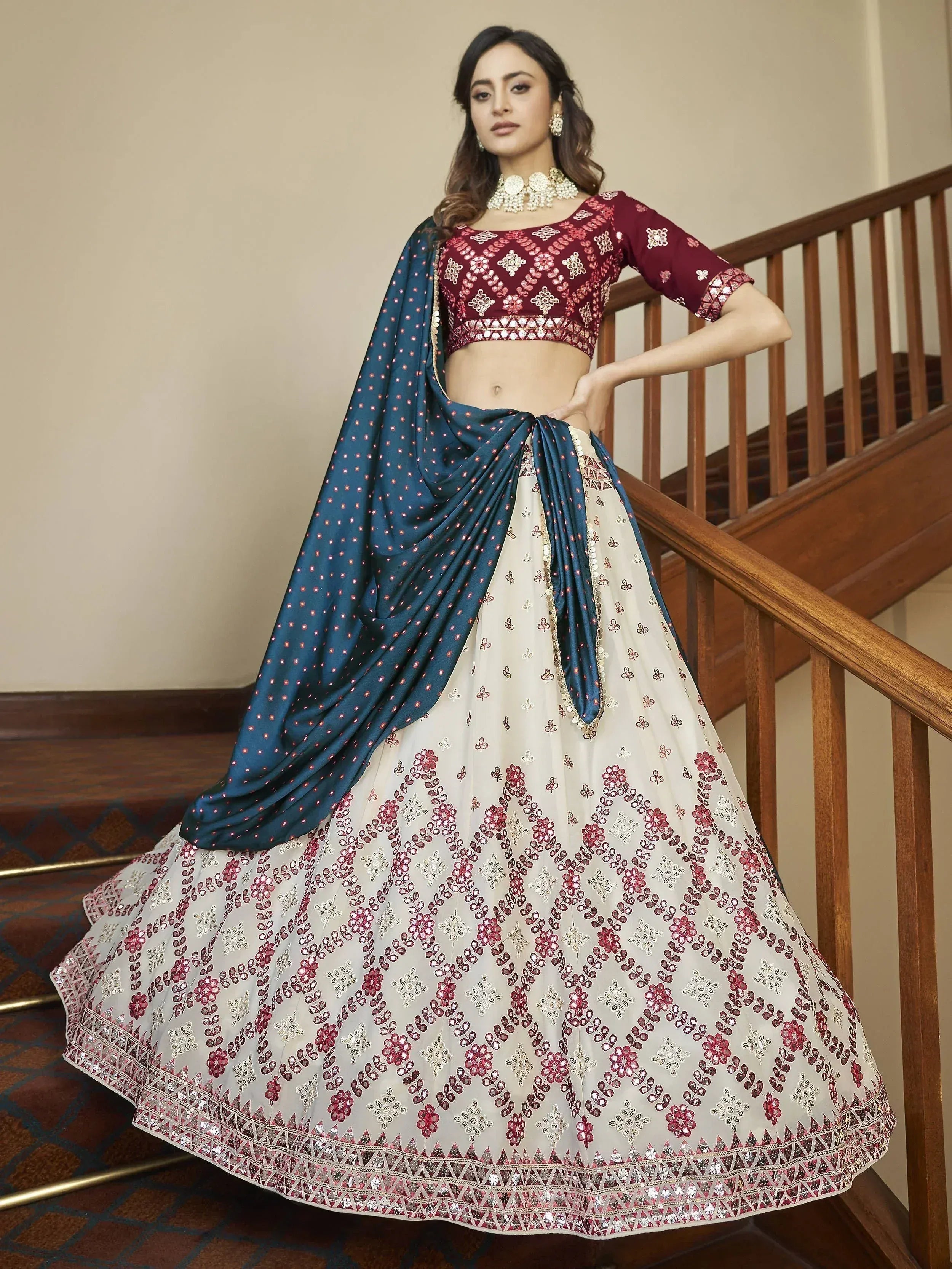 Elegant maroon and cream embroidered lehenga choli with teal dupatta, perfect for Indian ethnic occasions.