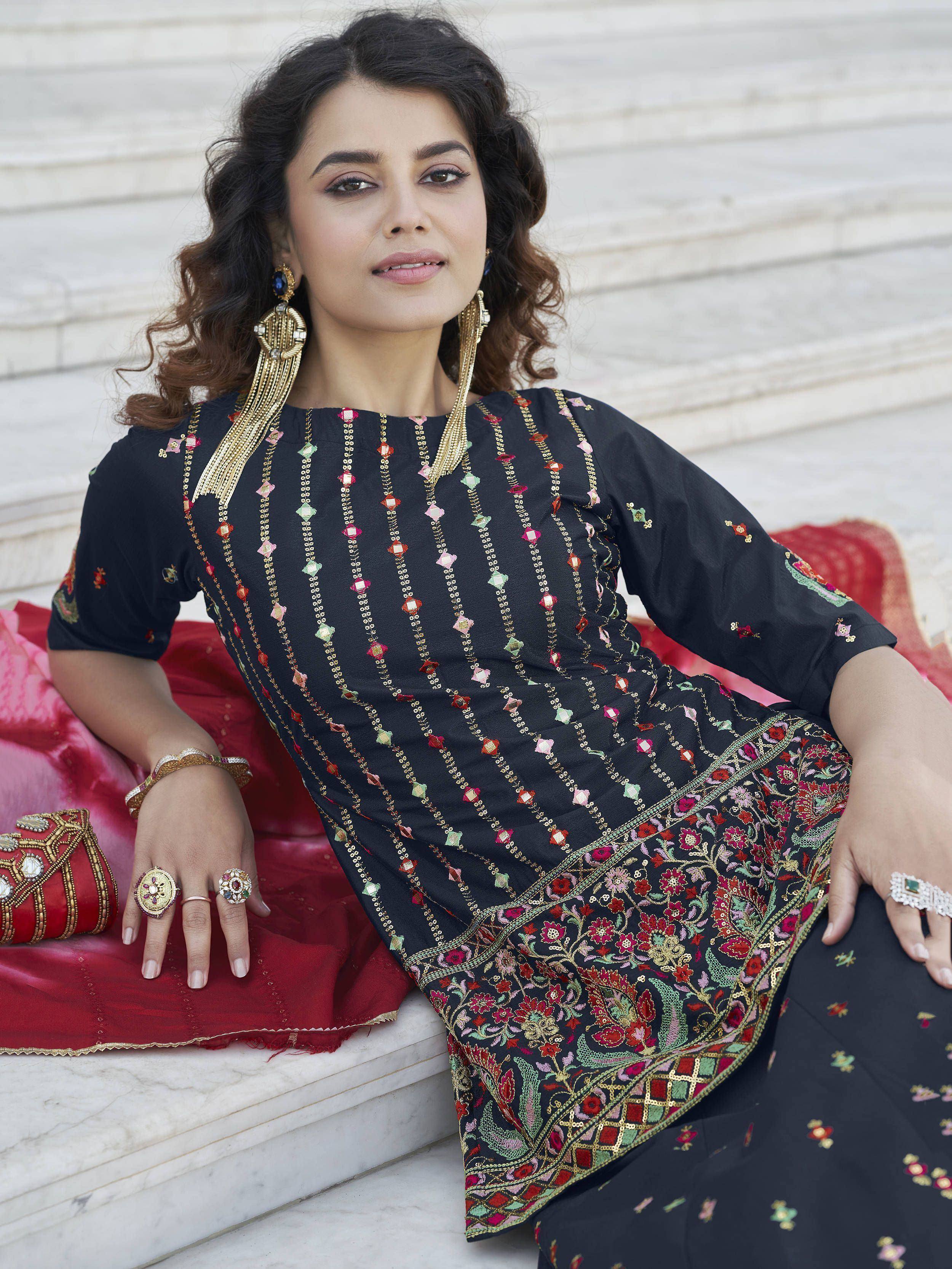 Black embroidered ethnic kurta with floral motifs, paired with statement jewelry and red dupatta