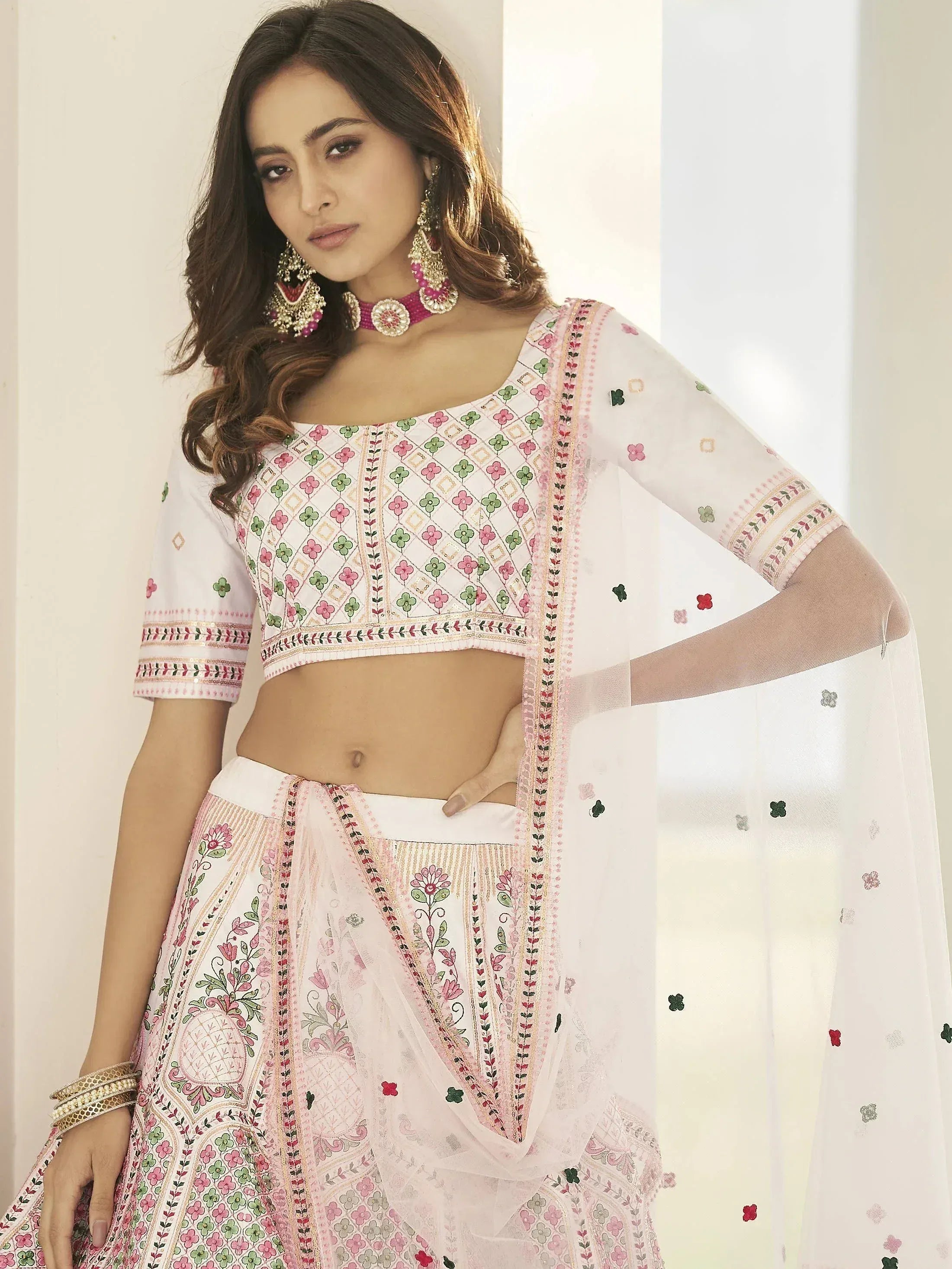White floral embroidered lehenga choli with pink green accents, sheer dupatta, traditional Indian ethnic wear