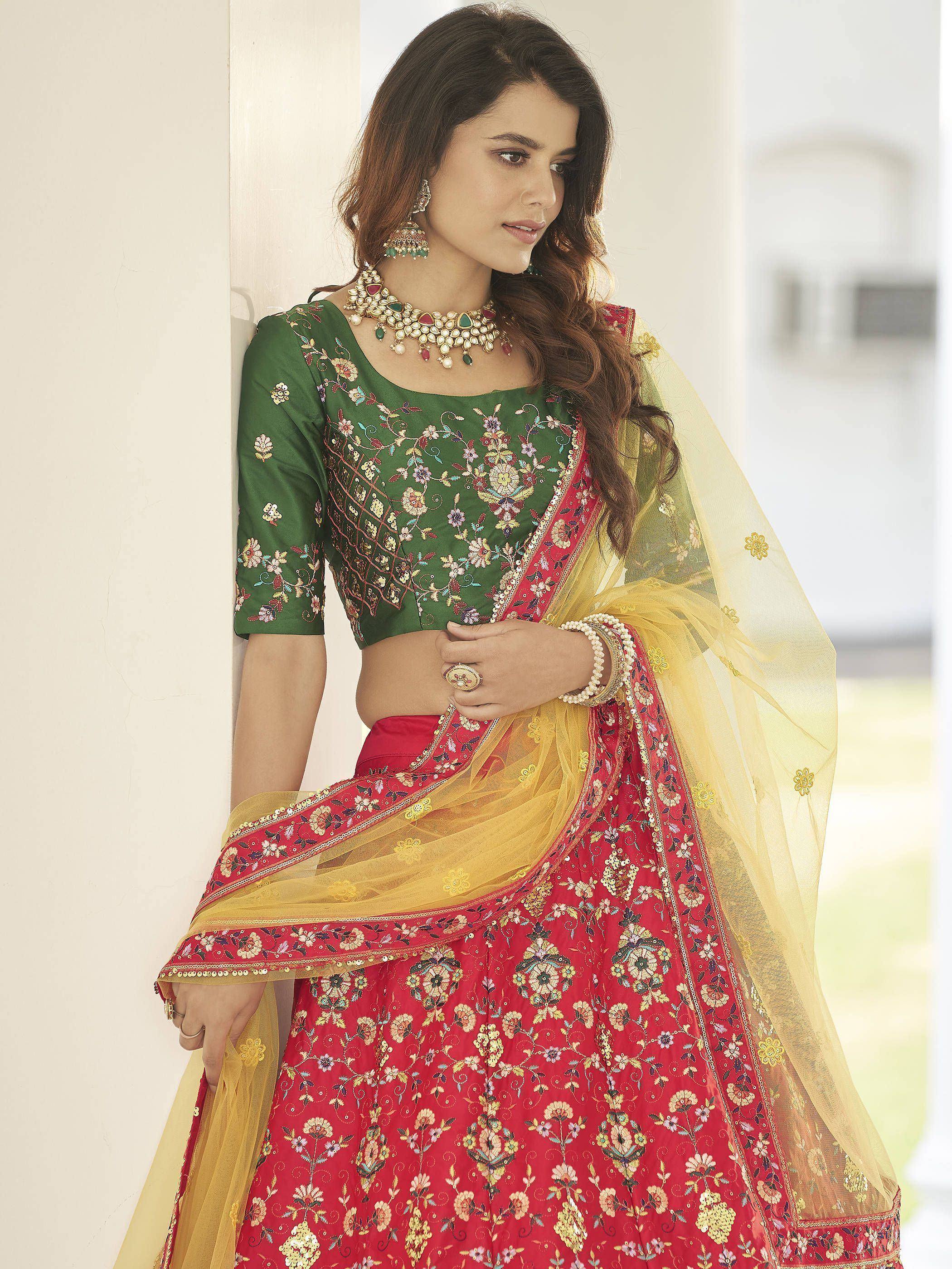 Green and red embroidered lehenga choli with floral patterns and yellow dupatta, styled with traditional jewelry.