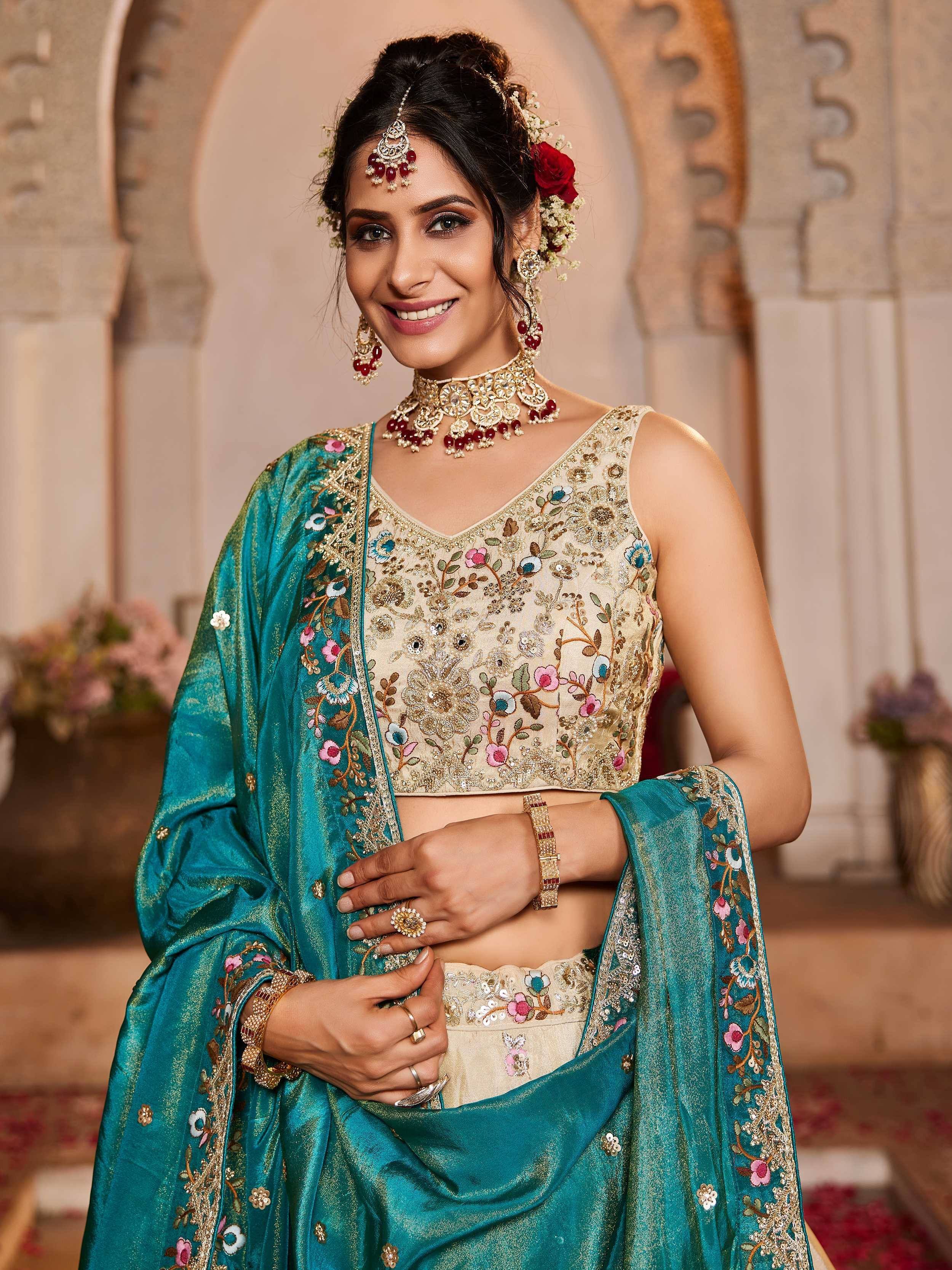 Elegant Indian ethnic wear with floral embroidery, gold detailing, and teal dupatta for weddings or festivals