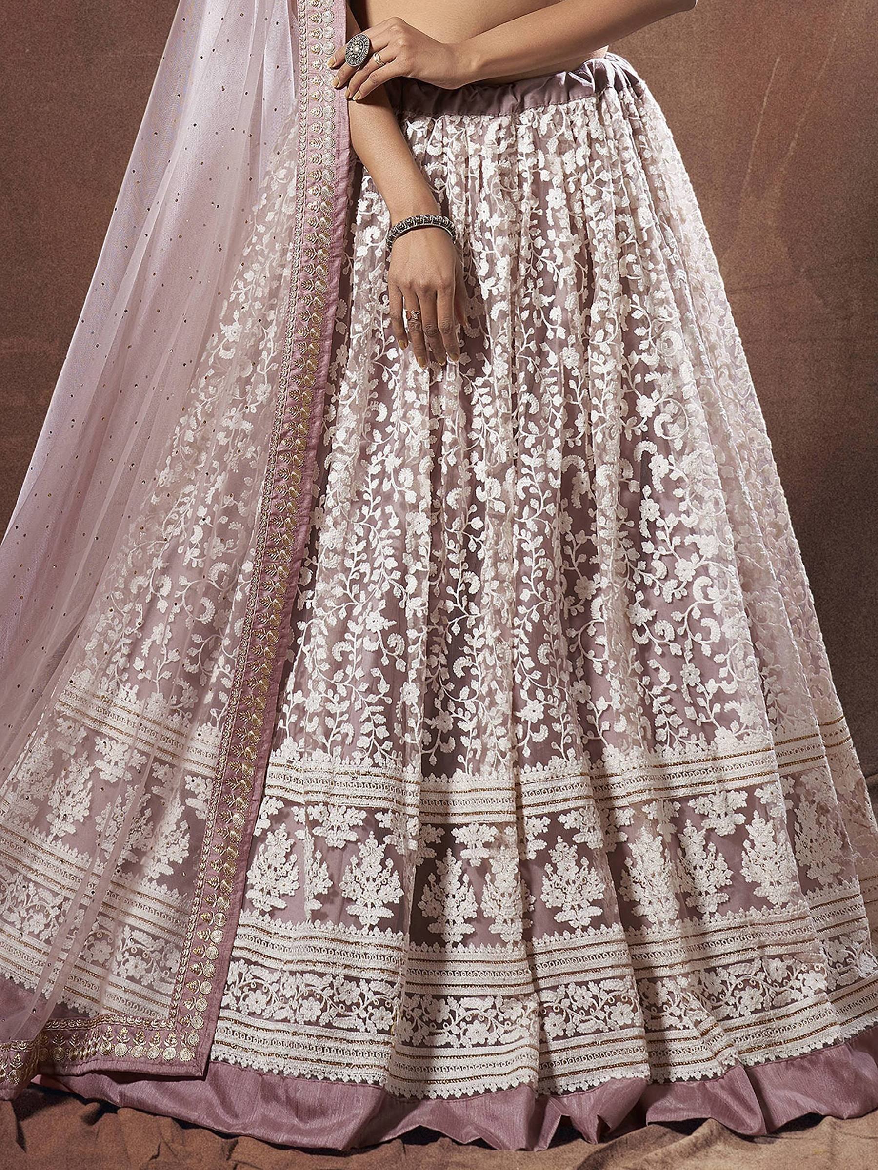 Elegant mauve lehenga choli with intricate white floral embroidery and gold detailing, perfect for Indian ethnic wear.