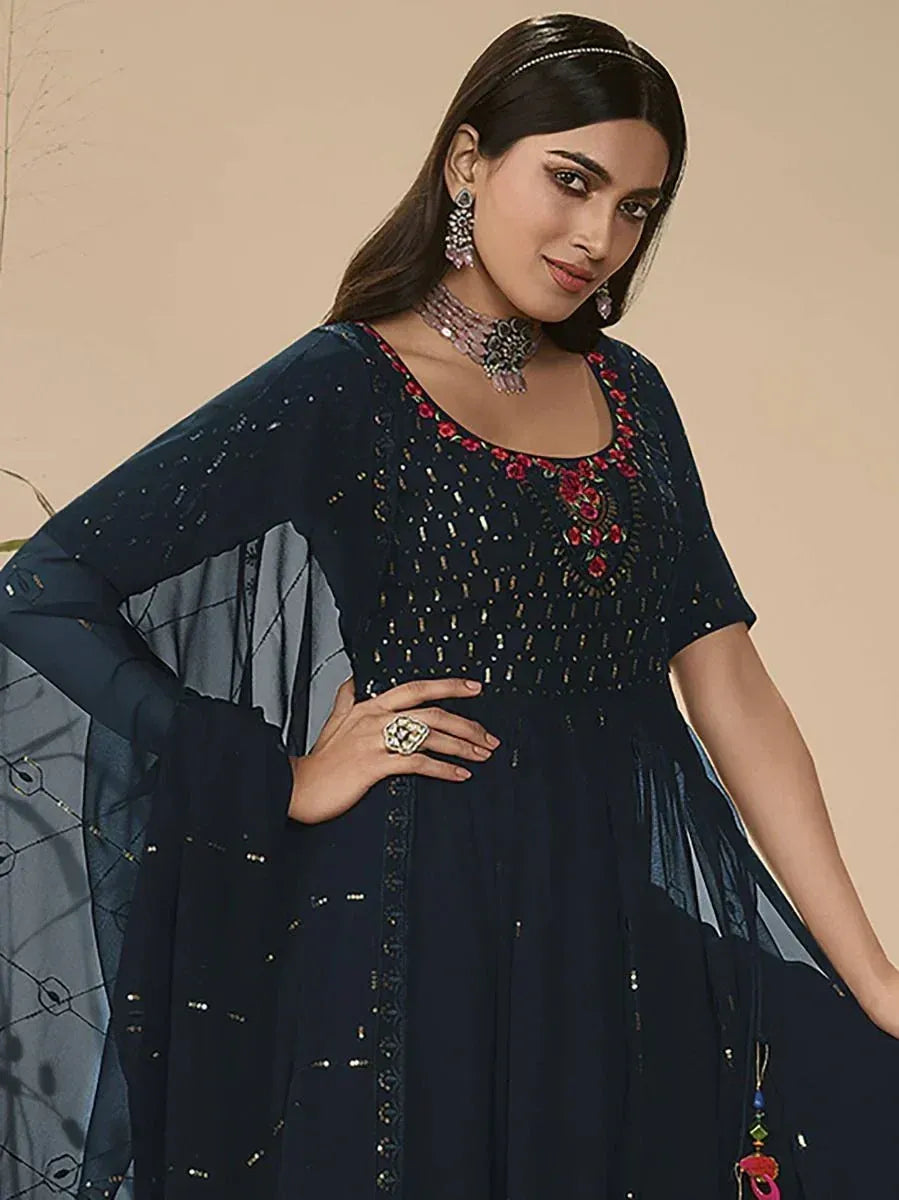 Woman wearing navy blue designer ethnic gown with sheer embellished dupatta and floral embroidery