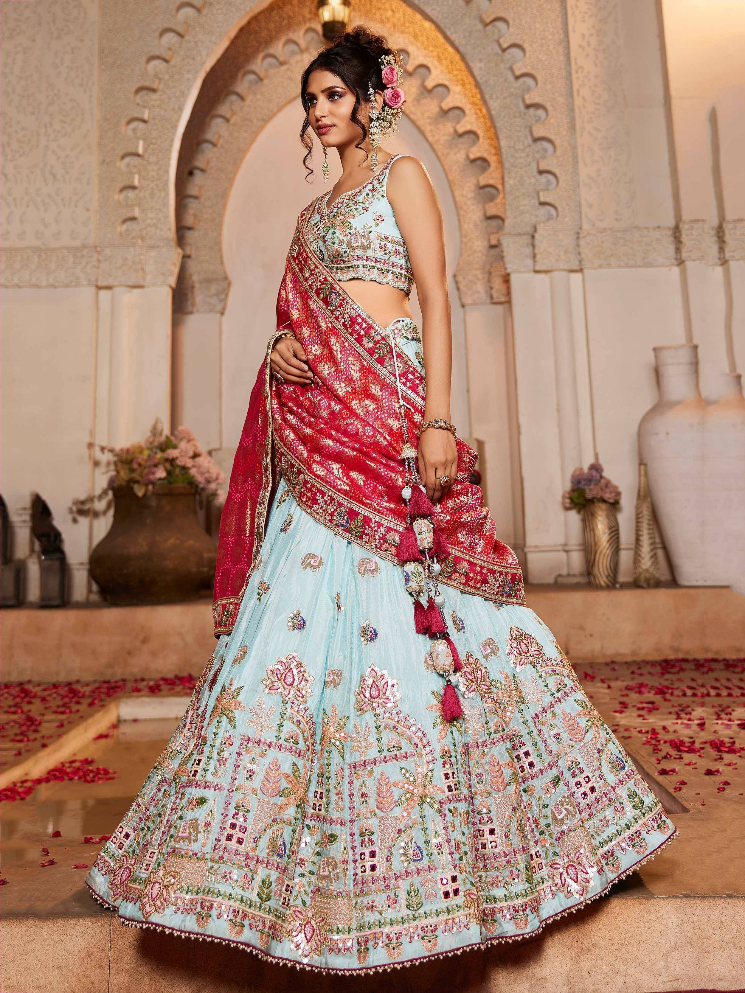 Light blue embroidered lehenga choli with red dupatta, floral motifs, and tassels for Indian ethnic wear