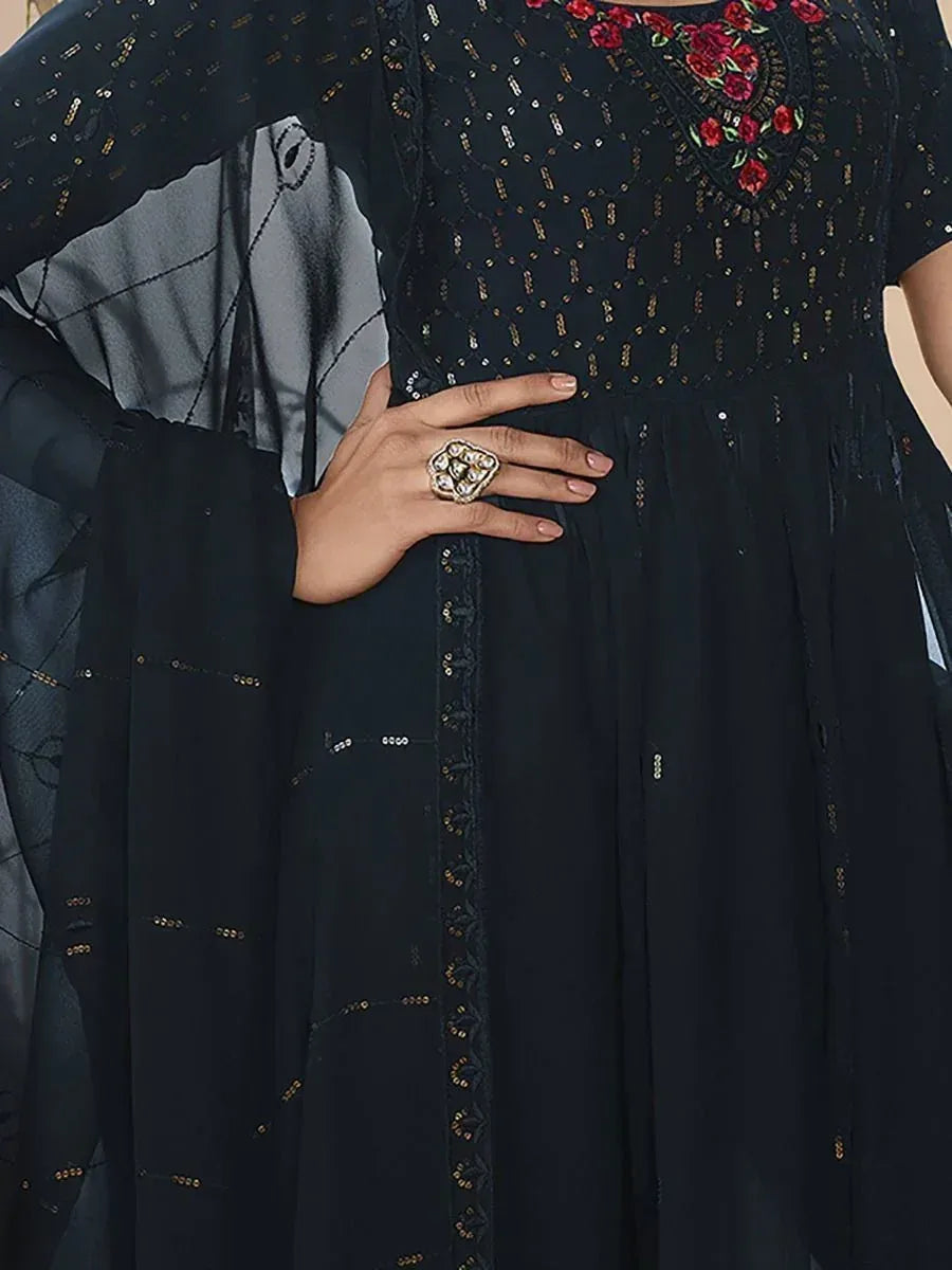 Woman wearing black embroidered ethnic gown with gold sequin details and statement ring