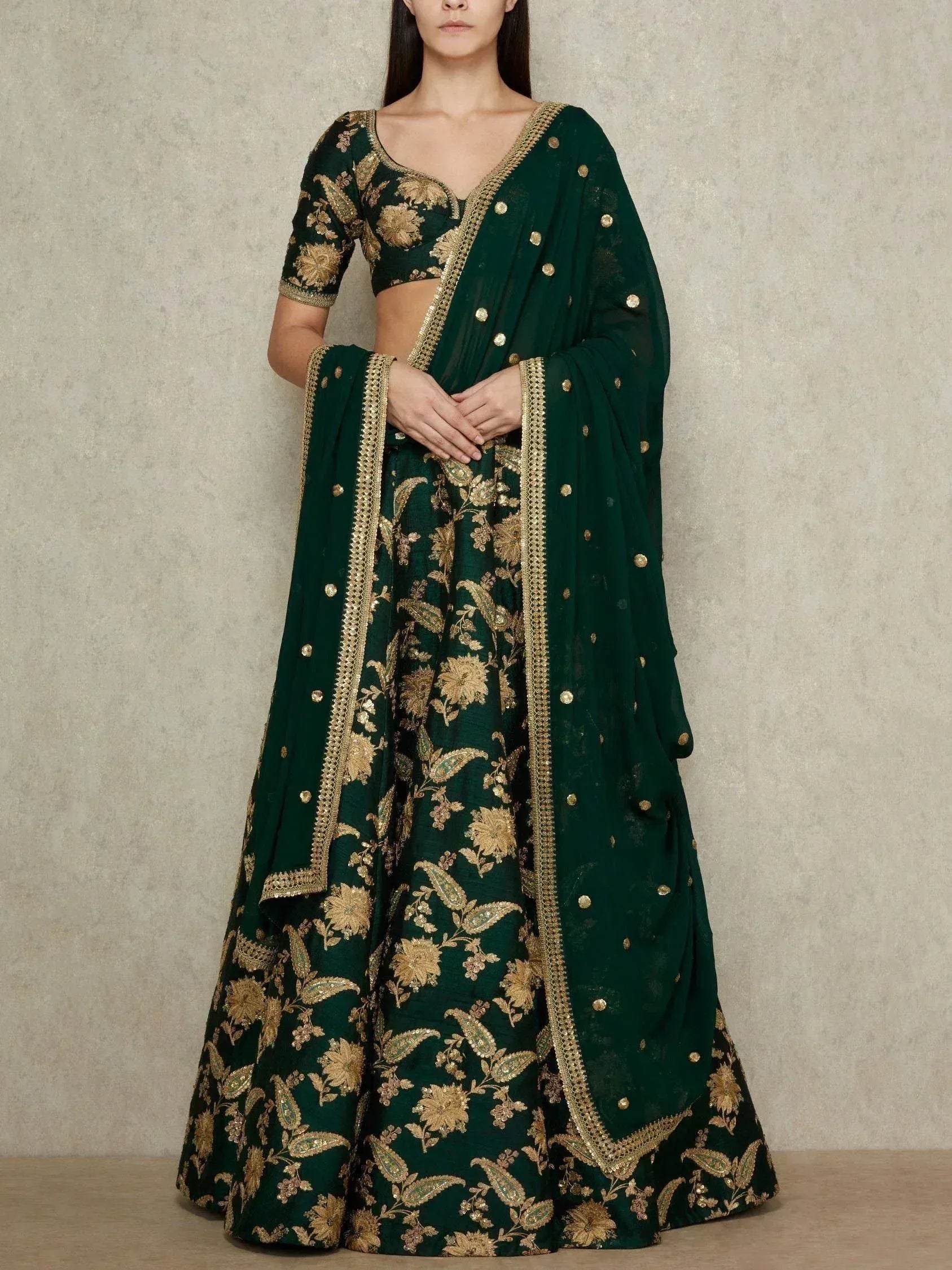Emerald green lehenga choli with gold floral embroidery and matching dupatta, ideal for Indian ethnic occasions.
