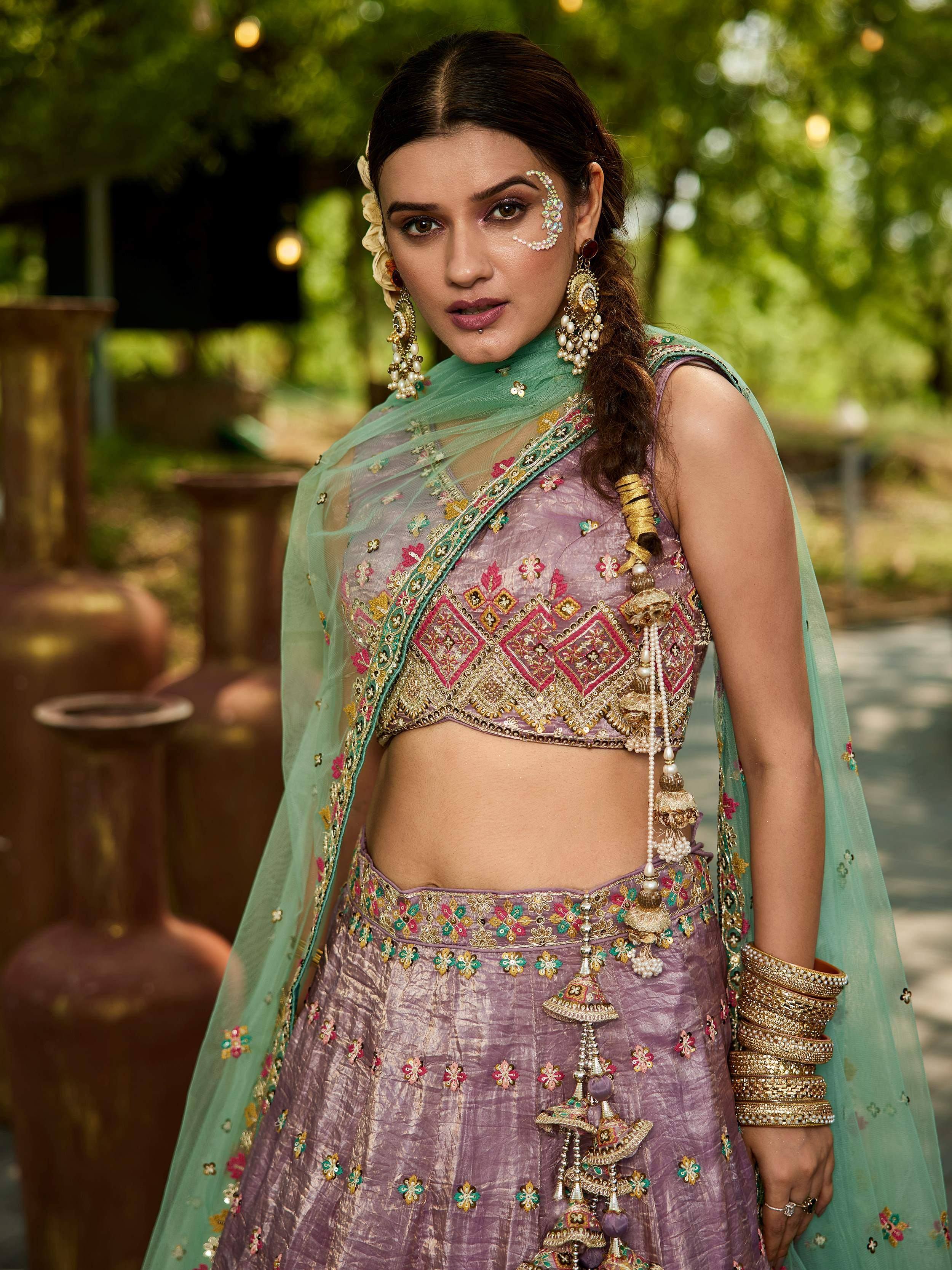 Elegant purple lehenga choli with gold embroidery, floral motifs, and mint dupatta, perfect for Indian weddings or festive occasions.