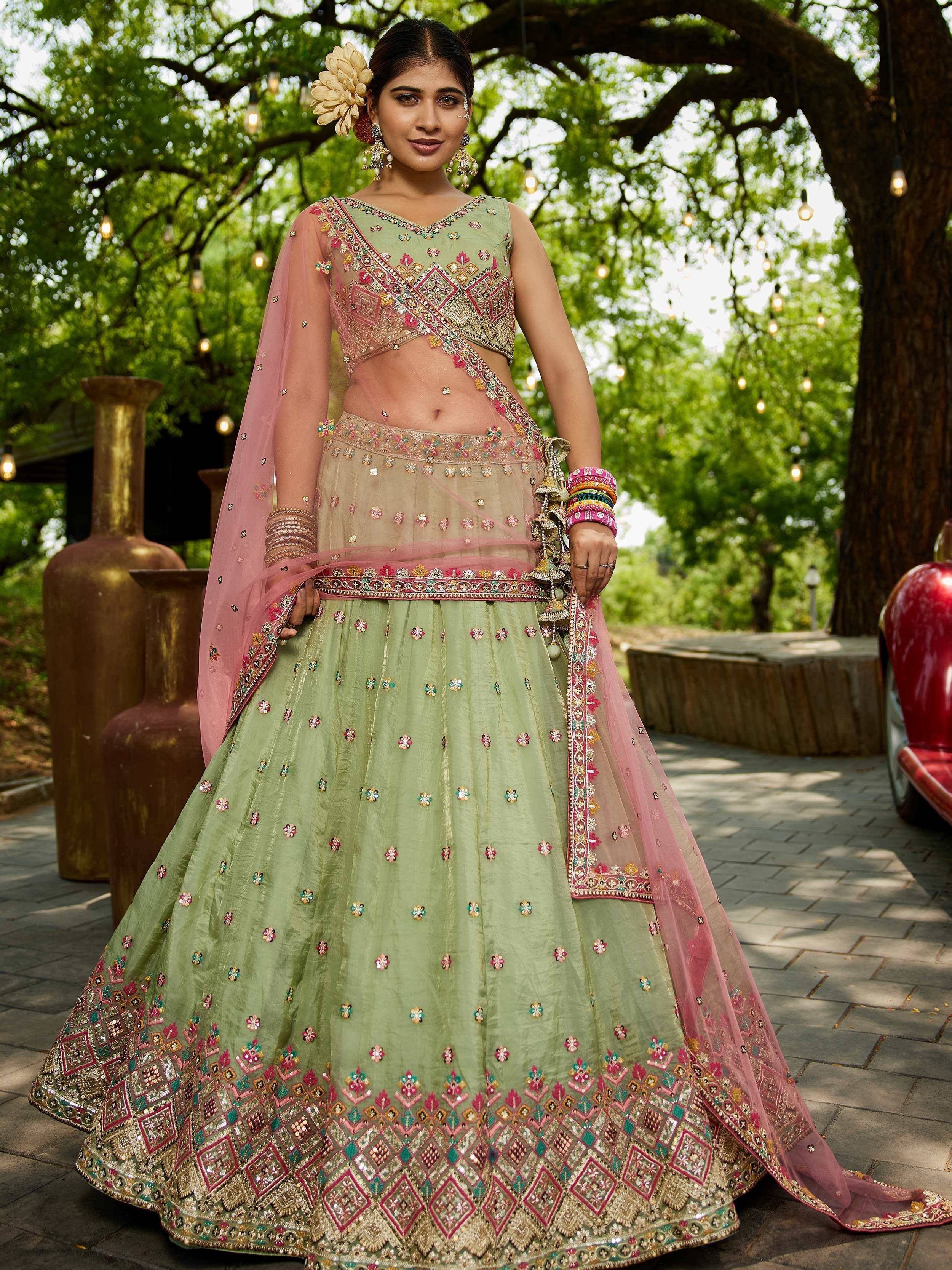 Green embroidered lehenga choli with pink dupatta, perfect for Indian weddings and festive occasions.