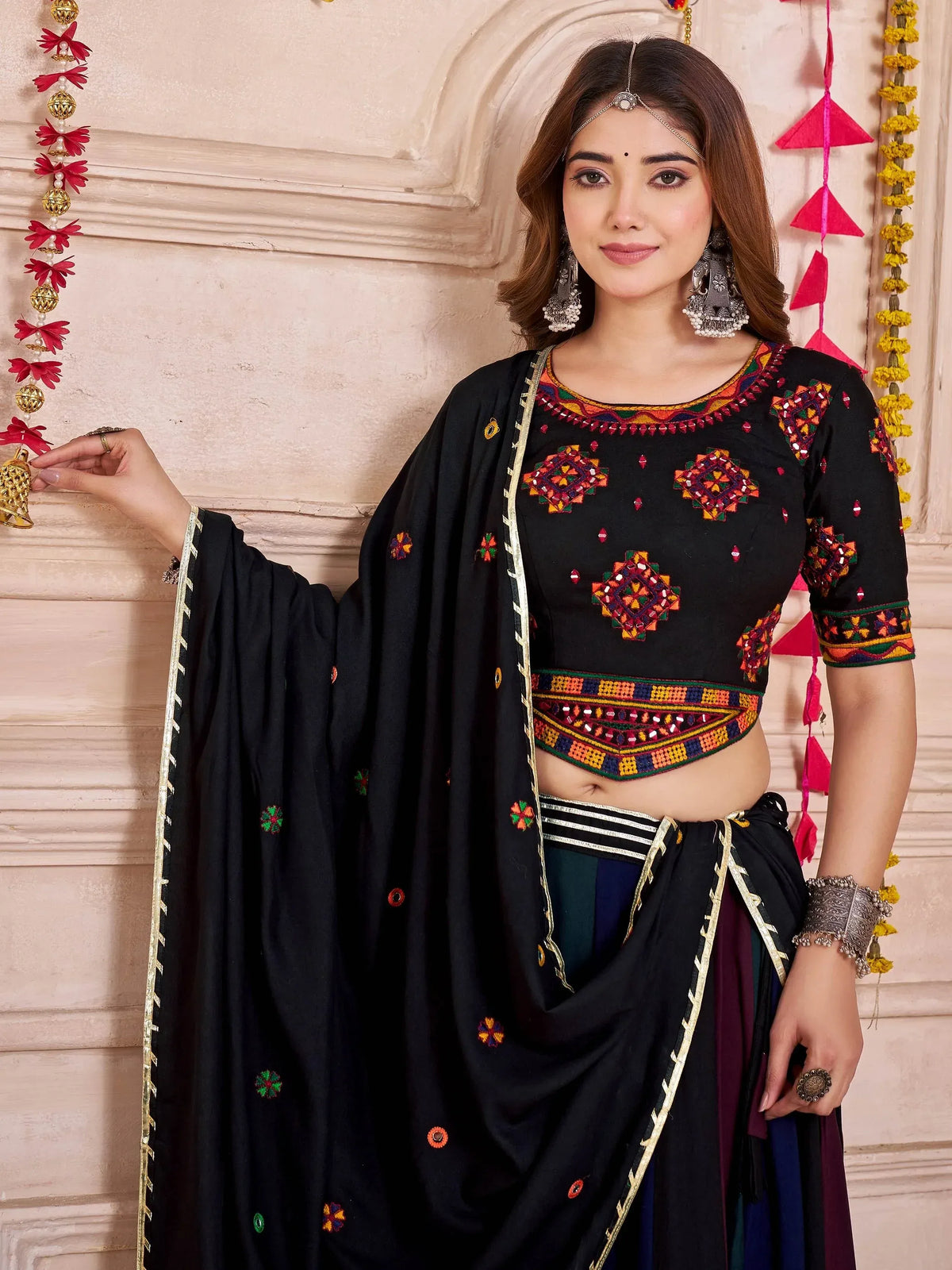 Black embroidered ethnic crop top with mirror work, paired with matching dupatta and skirt, perfect for Indian festivals.