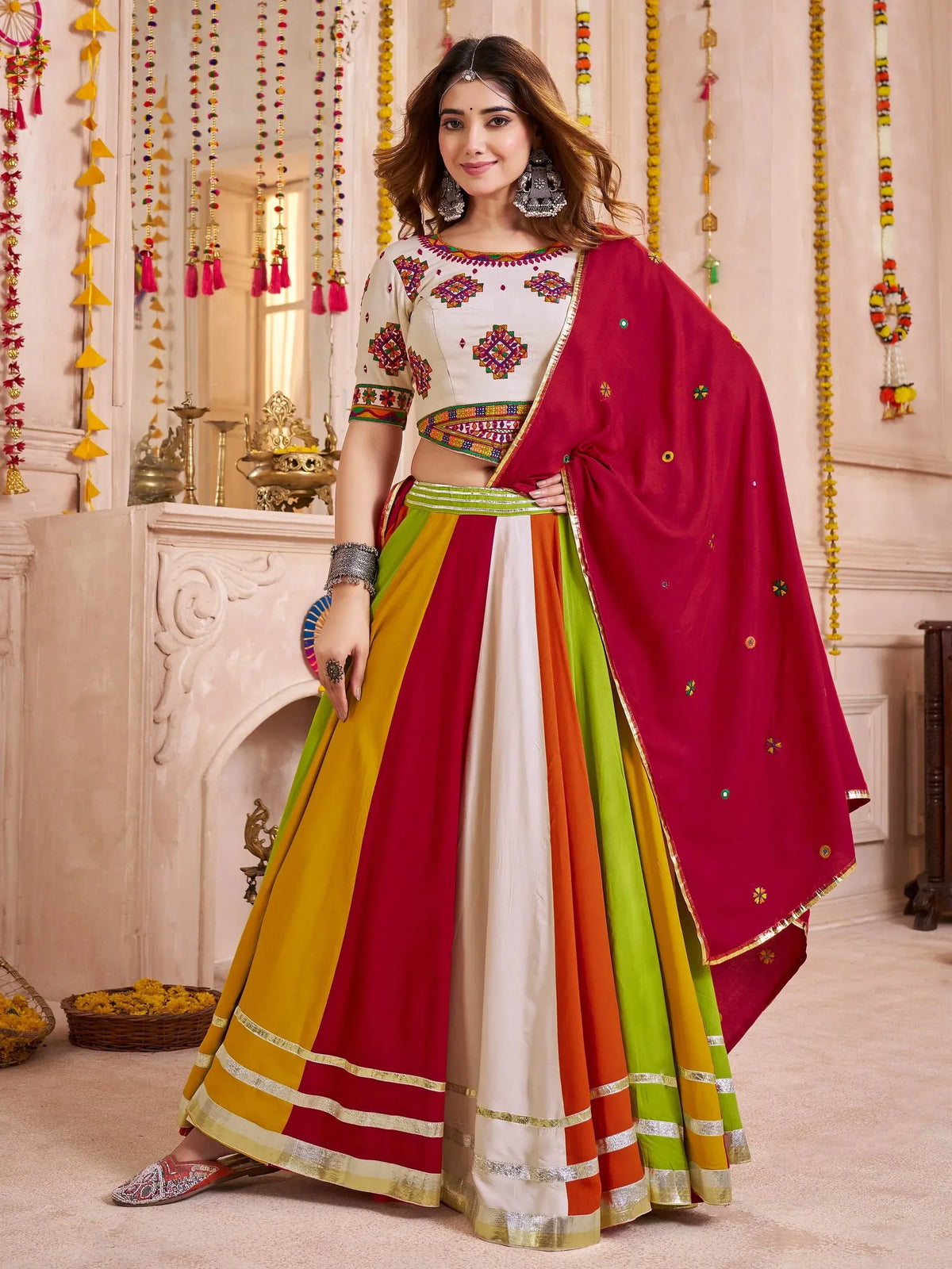 Colorful Indian lehenga choli with embroidered top, multi-panel skirt, and red dupatta for festive occasions