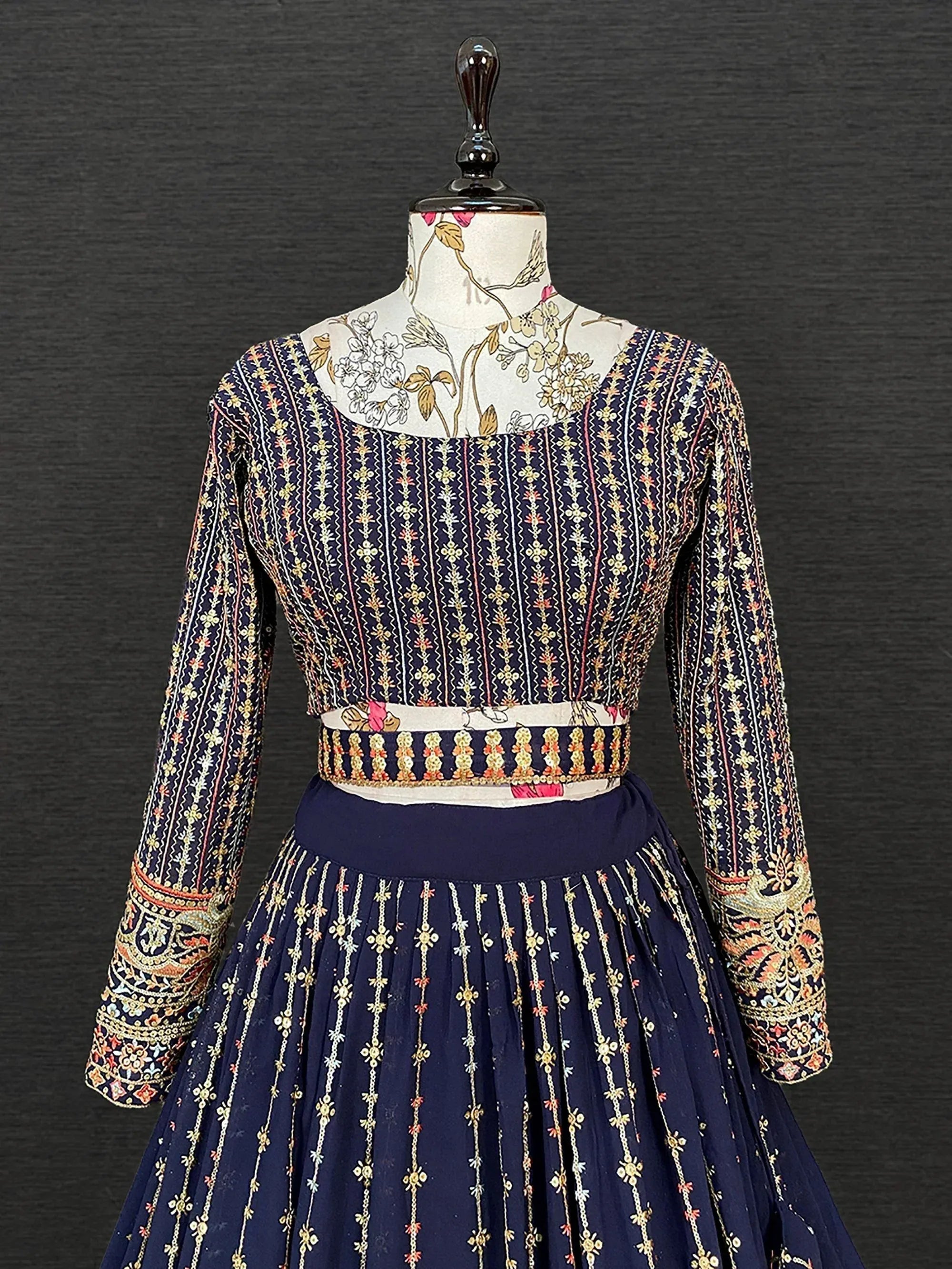 Navy blue embroidered lehenga choli with floral motifs and detailed sleeves, displayed on mannequin