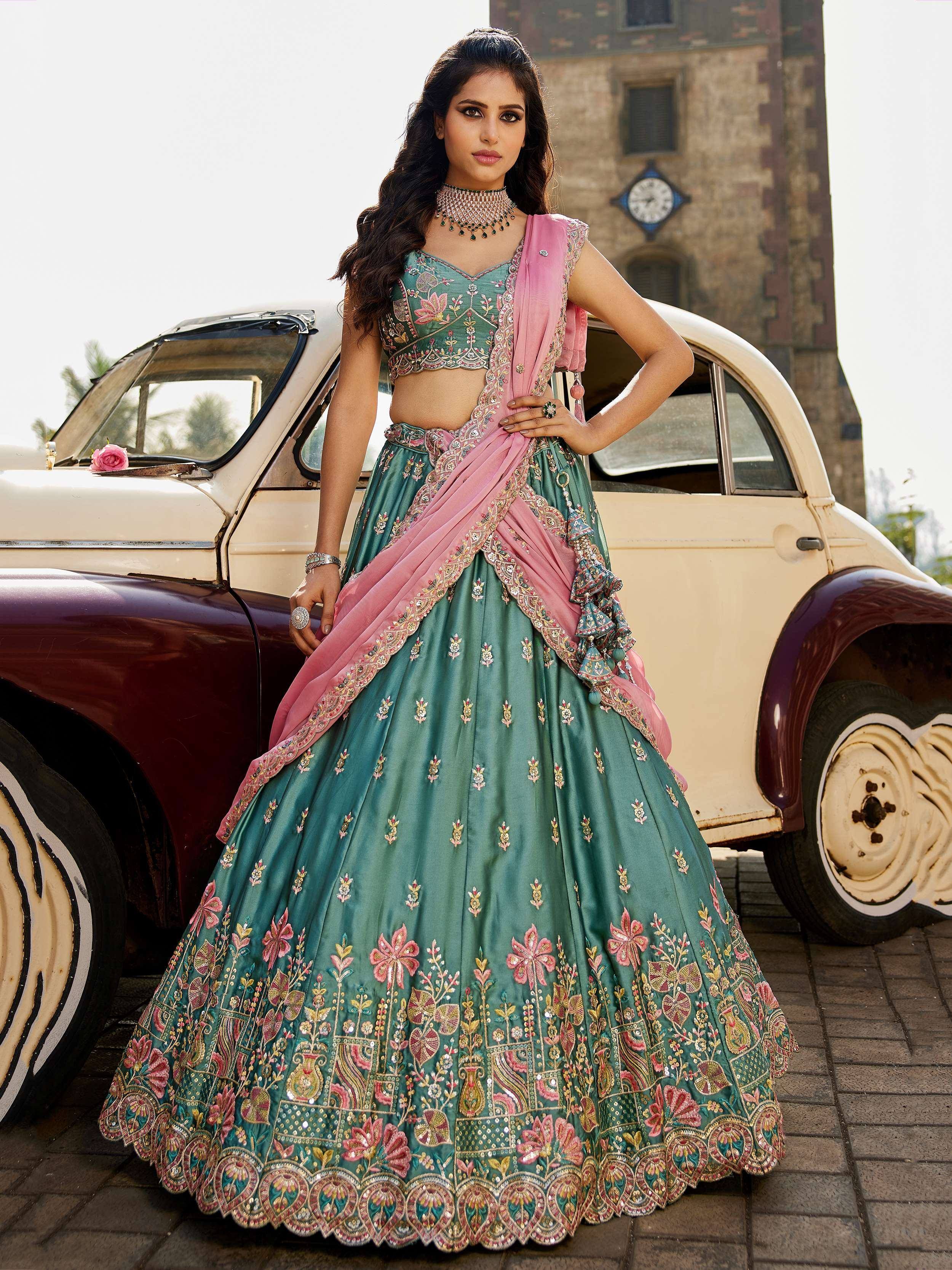 Teal and pink embroidered lehenga choli with floral motifs, styled with vintage car backdrop
