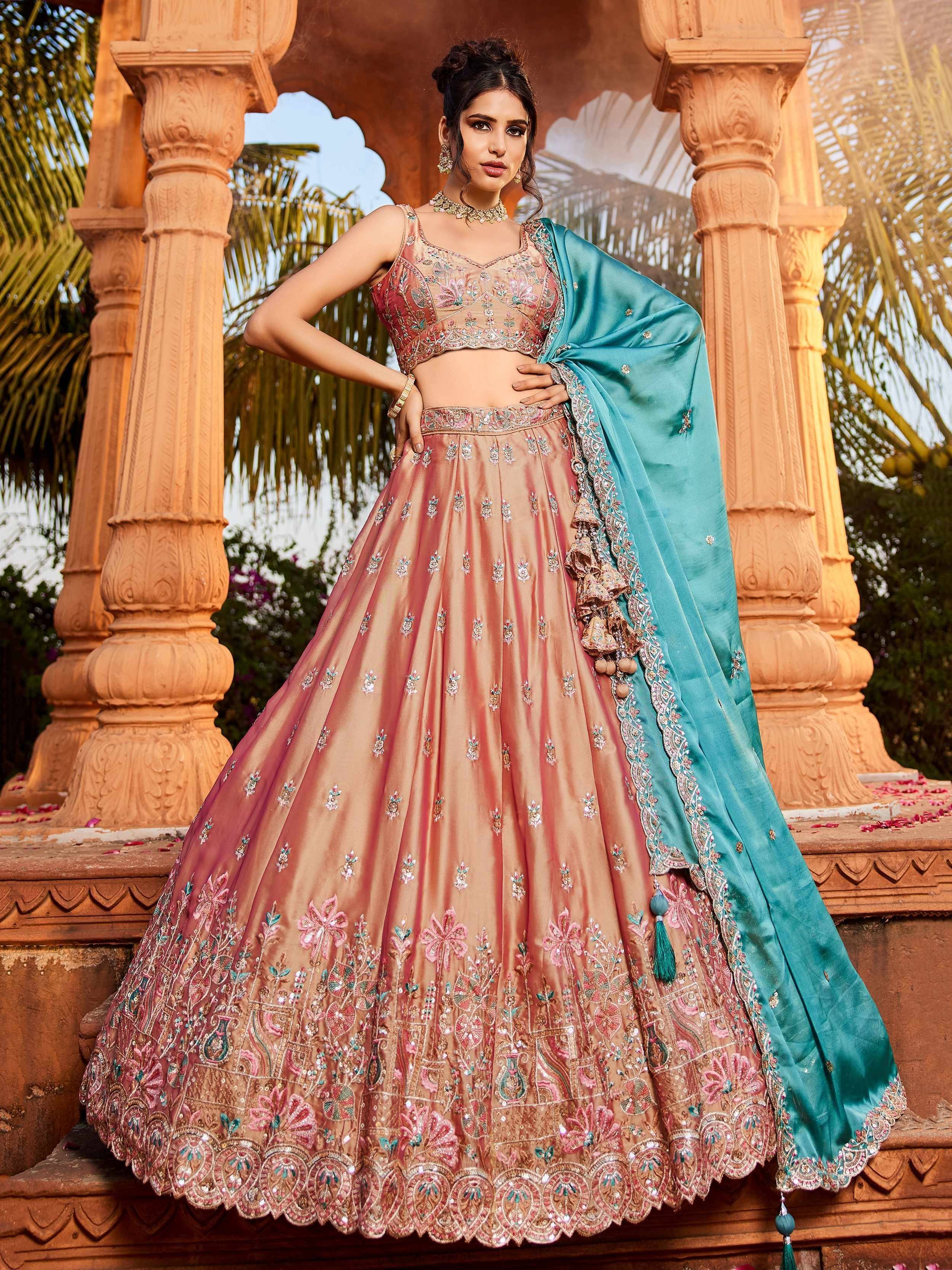 Elegant peach lehenga choli with turquoise dupatta, intricate floral embroidery, perfect for Indian weddings and festive occasions.