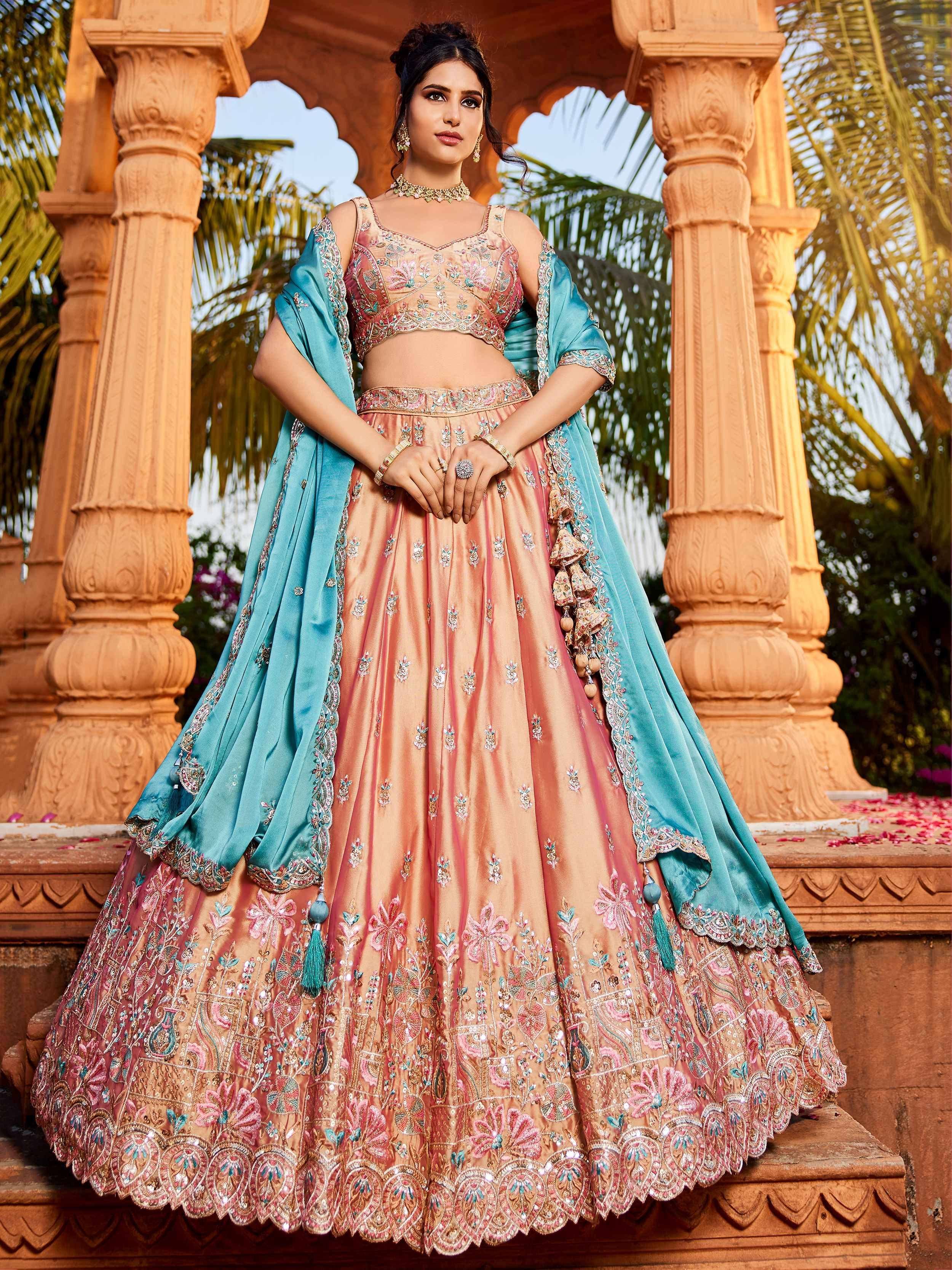 Elegant peach lehenga choli with blue dupatta, floral embroidery, perfect for Indian weddings and festive occasions.