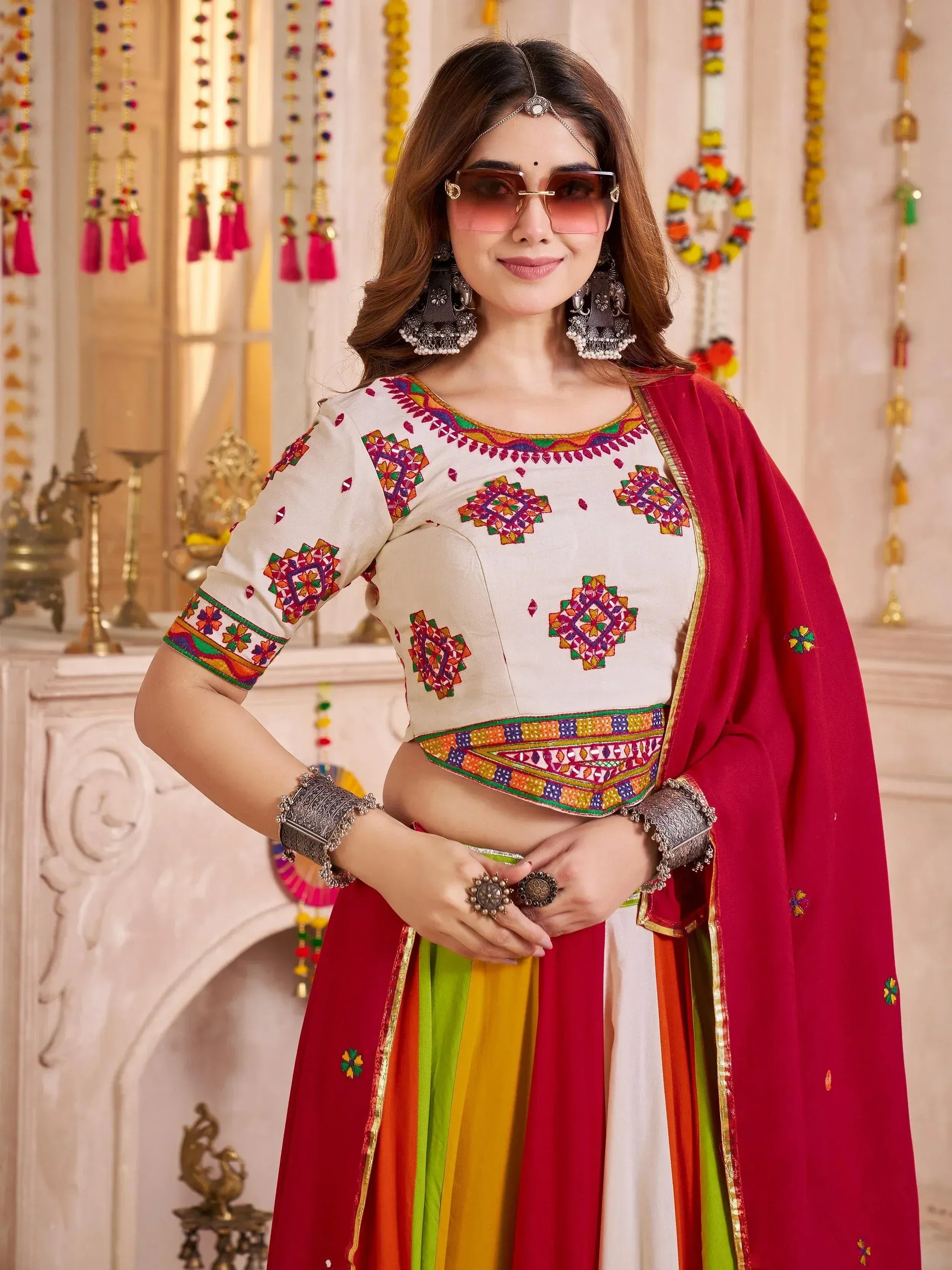 Woman in colorful embroidered Indian ethnic wear with mirror work, dupatta, and traditional jewelry