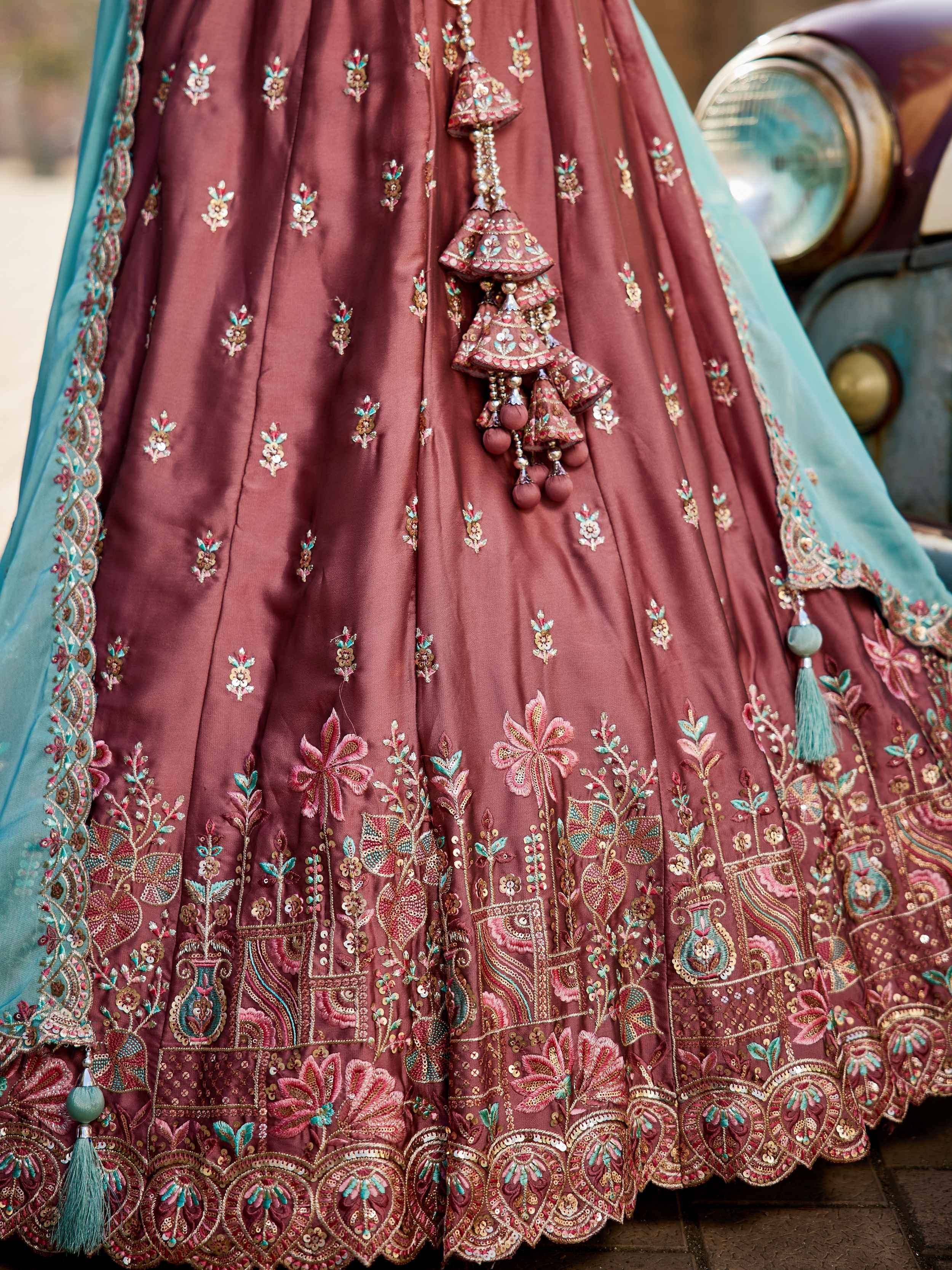 Maroon designer lehenga with floral embroidery, tassels, and turquoise dupatta for Indian ethnic wear
