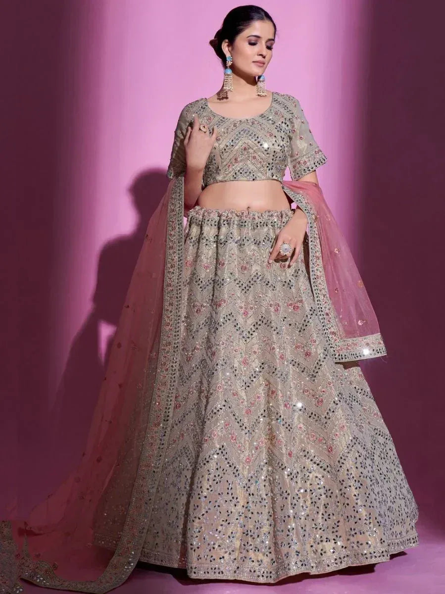 Designer lehenga choli with intricate embroidery and mirror work, paired with pink dupatta for ethnic occasions