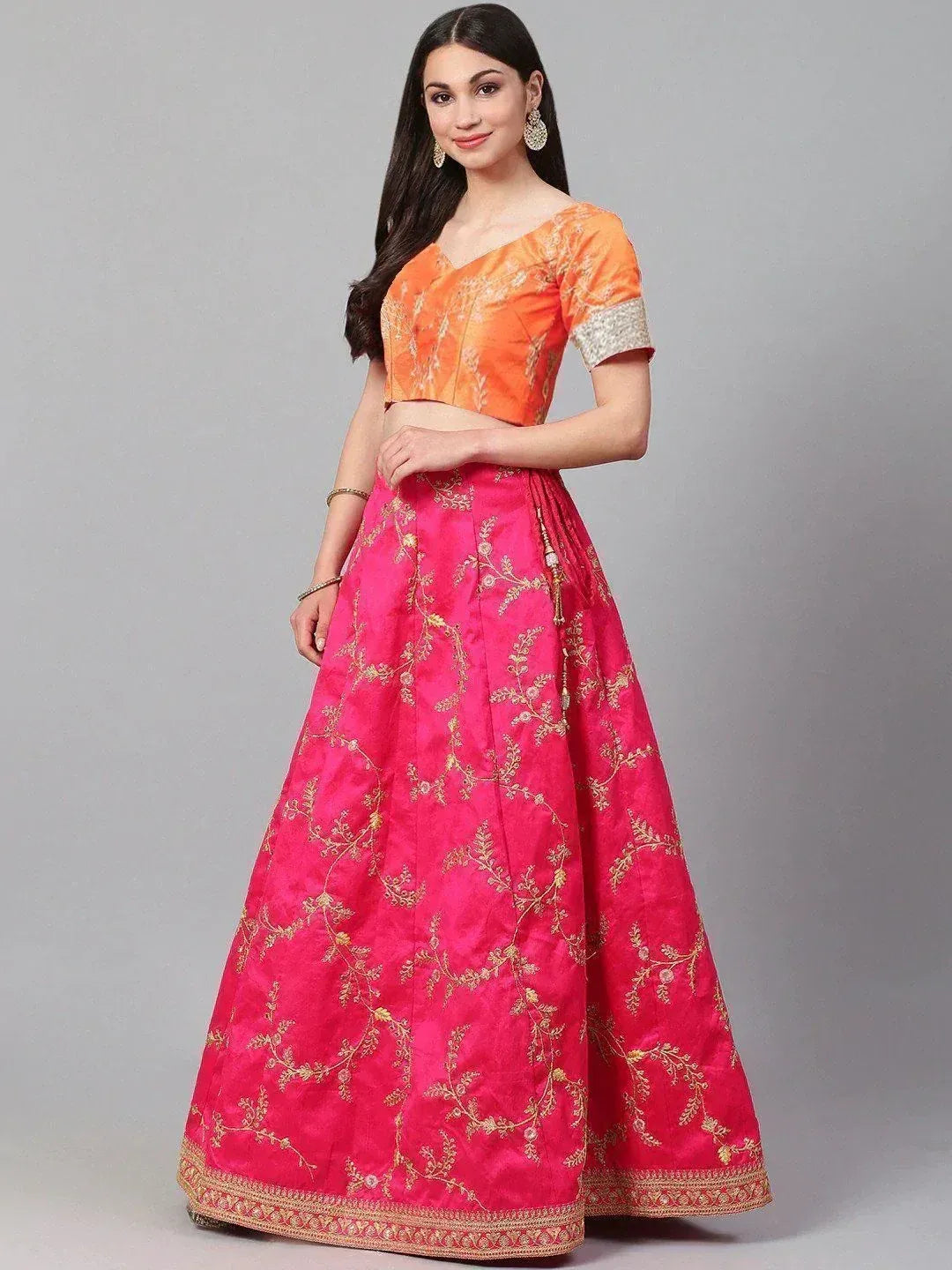 Vibrant pink and orange embroidered lehenga choli with gold floral detailing, perfect for Indian ethnic occasions