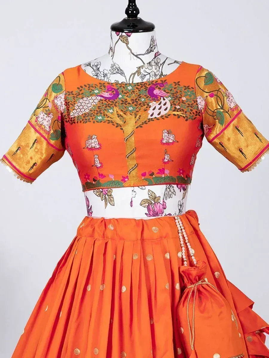 Vibrant orange lehenga choli with peacock tree print, gold accents, and pearl detailing for festive occasions