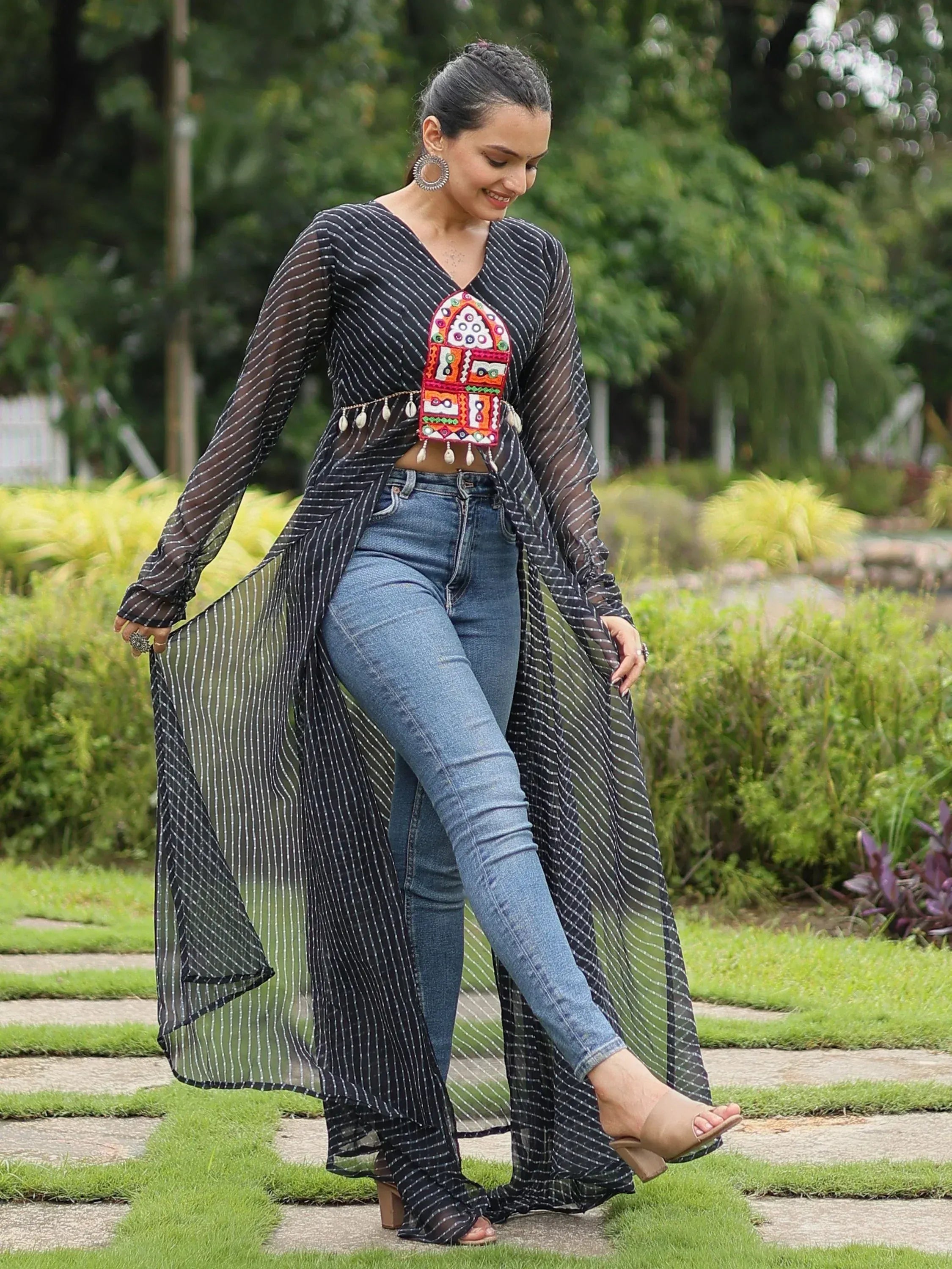 Black striped sheer ethnic top with colorful embroidery, paired with blue jeans for a fusion look
