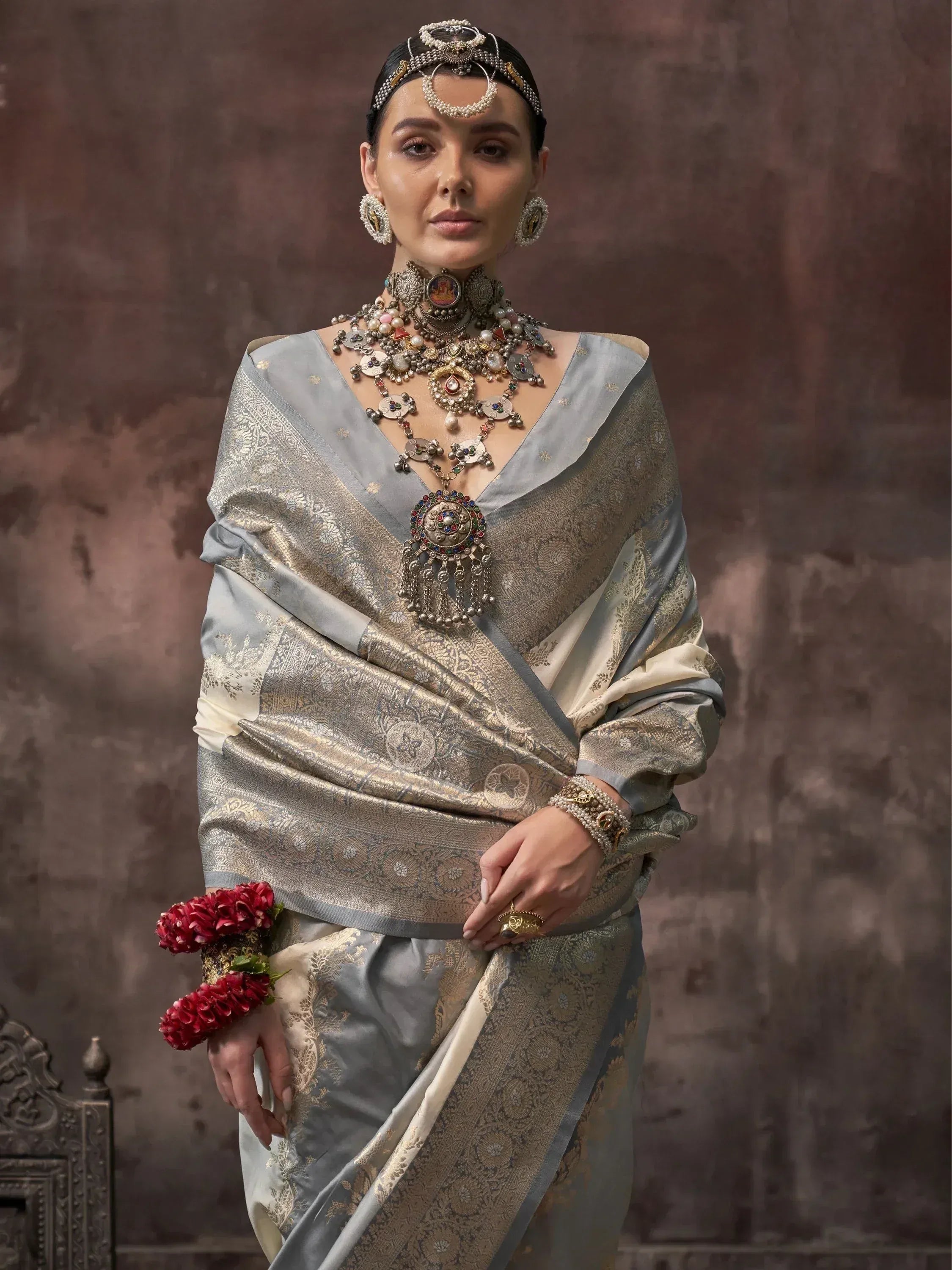 Elegant Indian ethnic saree with gold embroidery, traditional jewelry, and floral wrist accessory