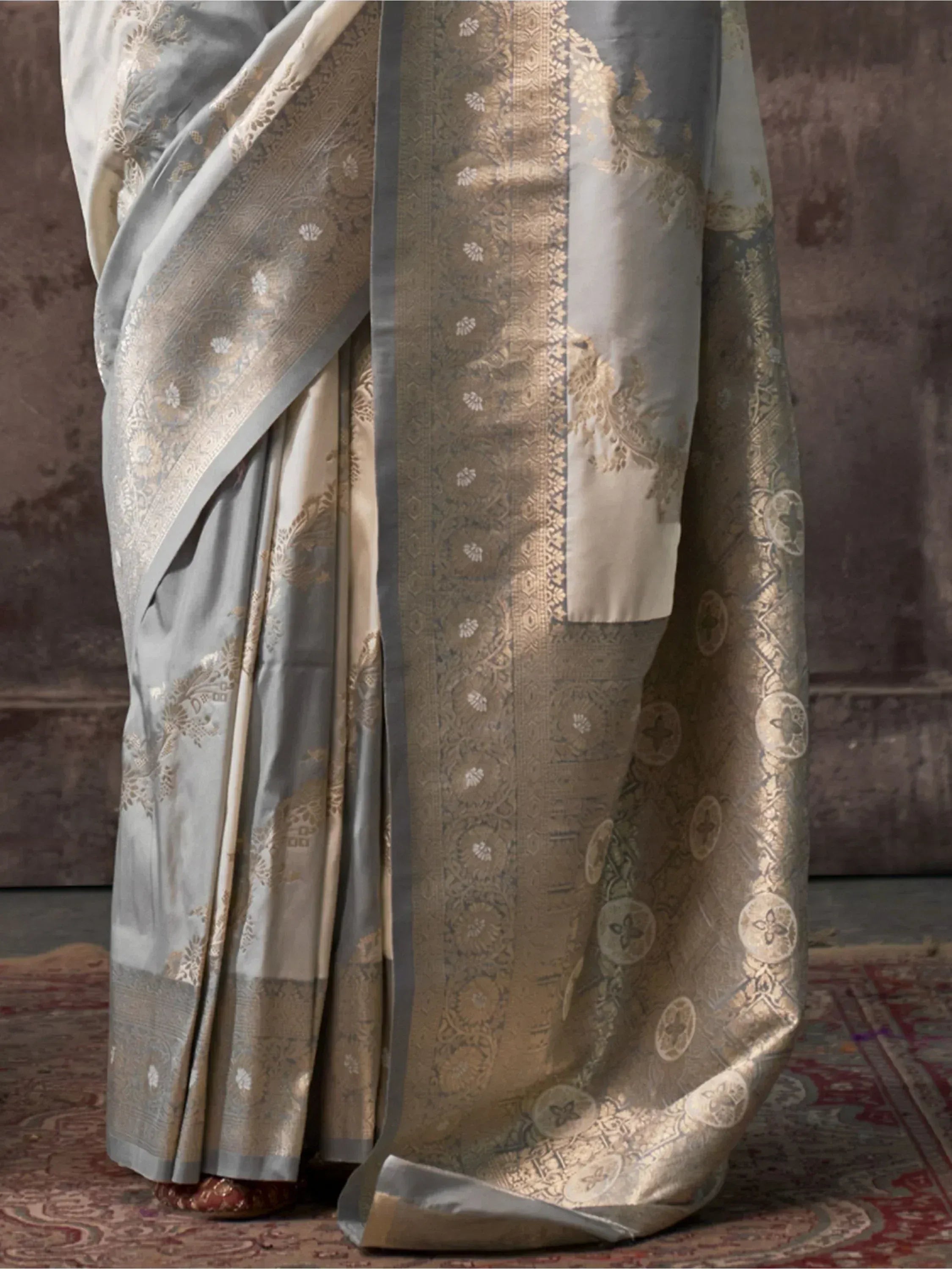 Elegant grey and gold designer saree with intricate floral zari work, perfect for Indian ethnic occasions.