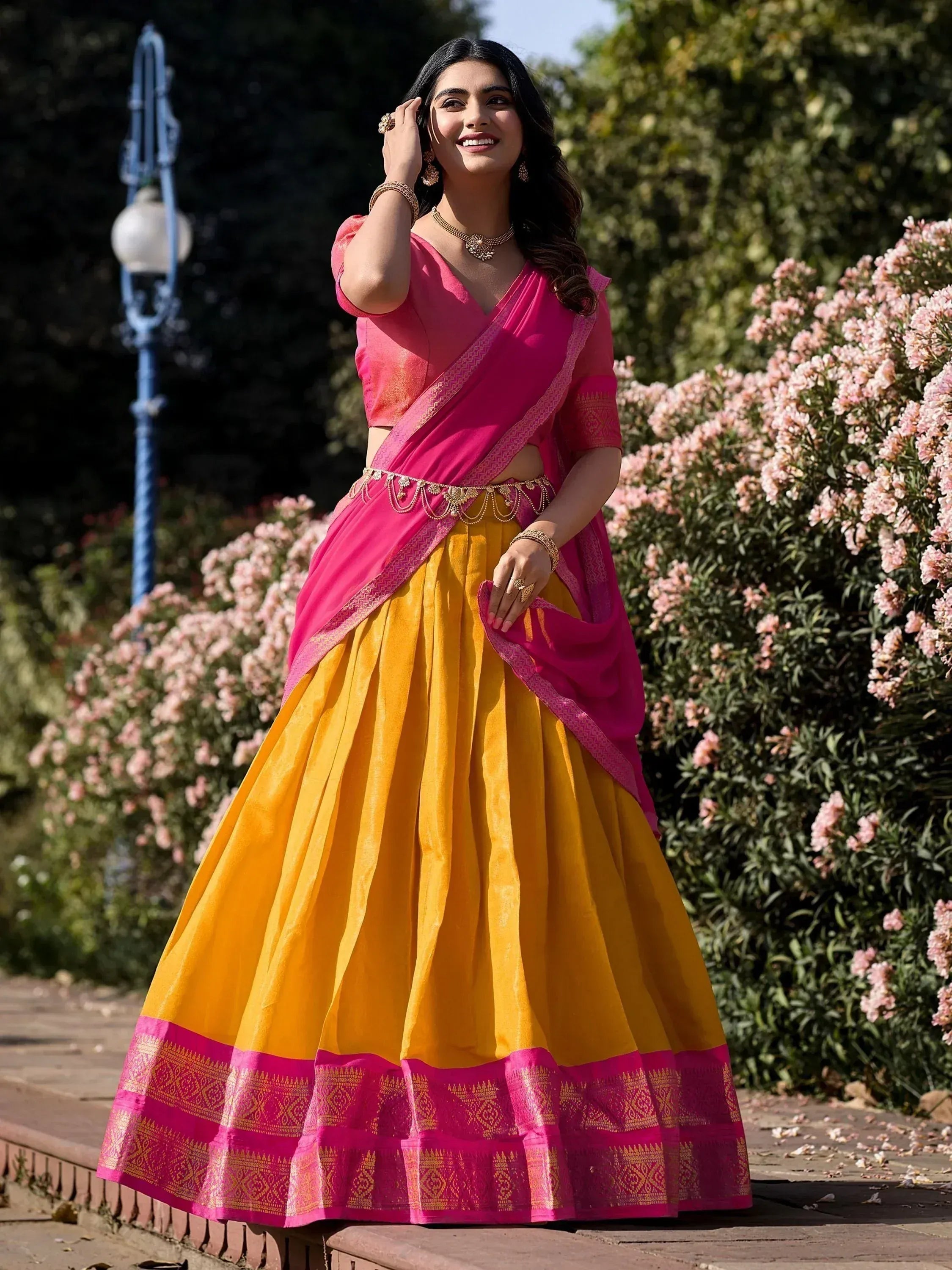 Vibrant pink and yellow designer lehenga choli with gold embroidery, perfect for Indian ethnic occasions.