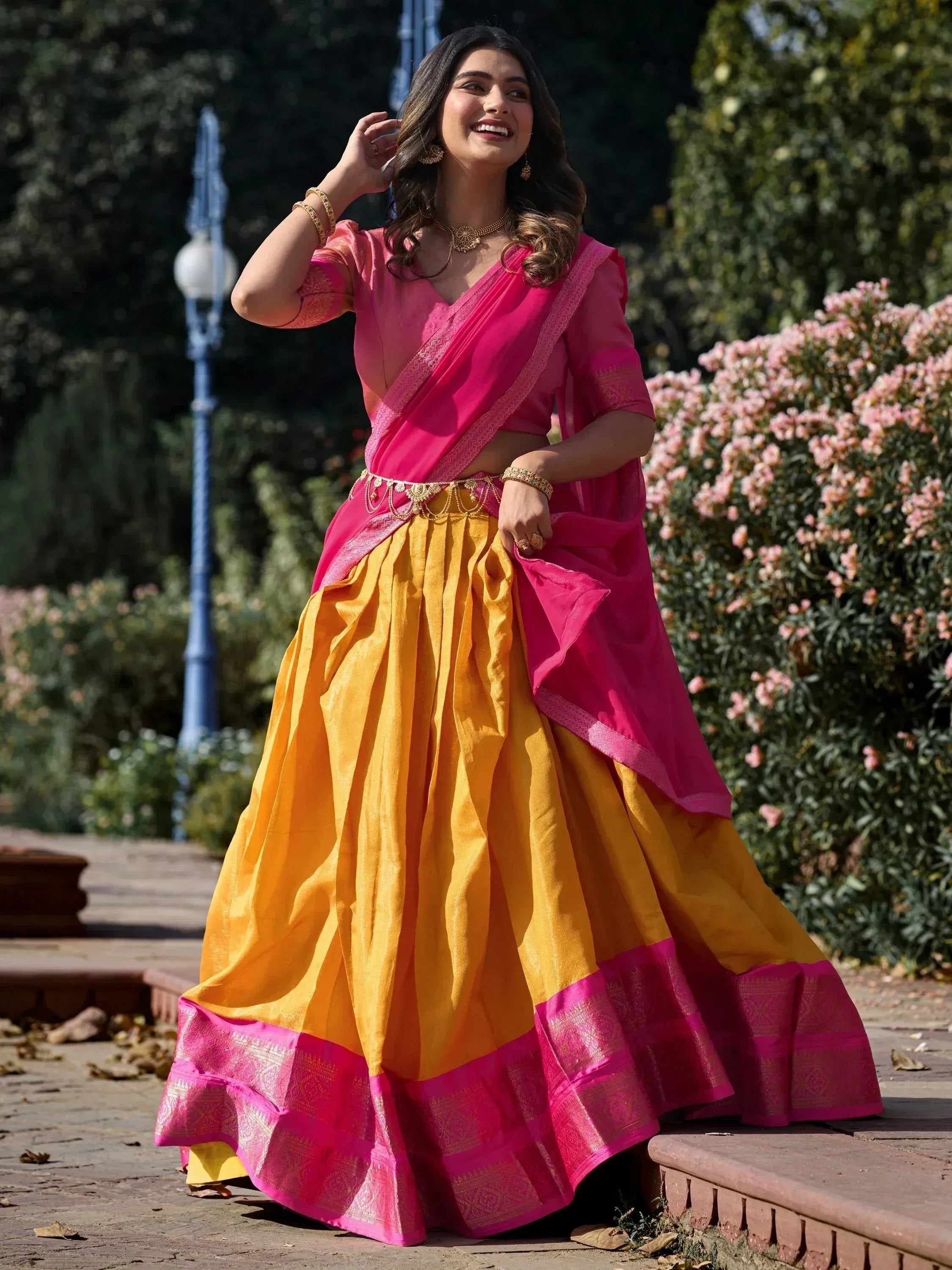 Vibrant pink and yellow designer lehenga choli with gold embroidery, perfect for Indian ethnic occasions.