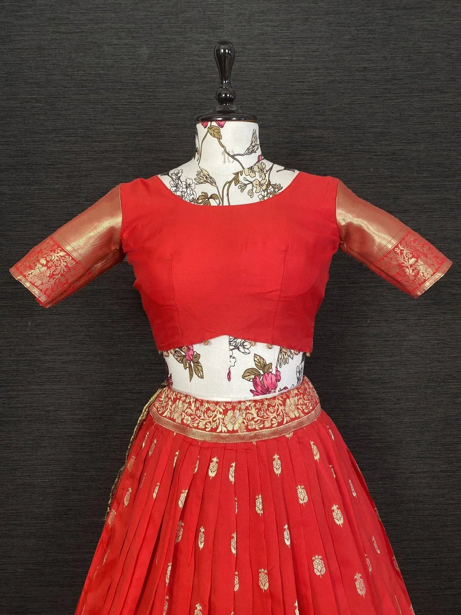 Red ethnic lehenga choli with gold embroidery and floral patterns, perfect for festive occasions.