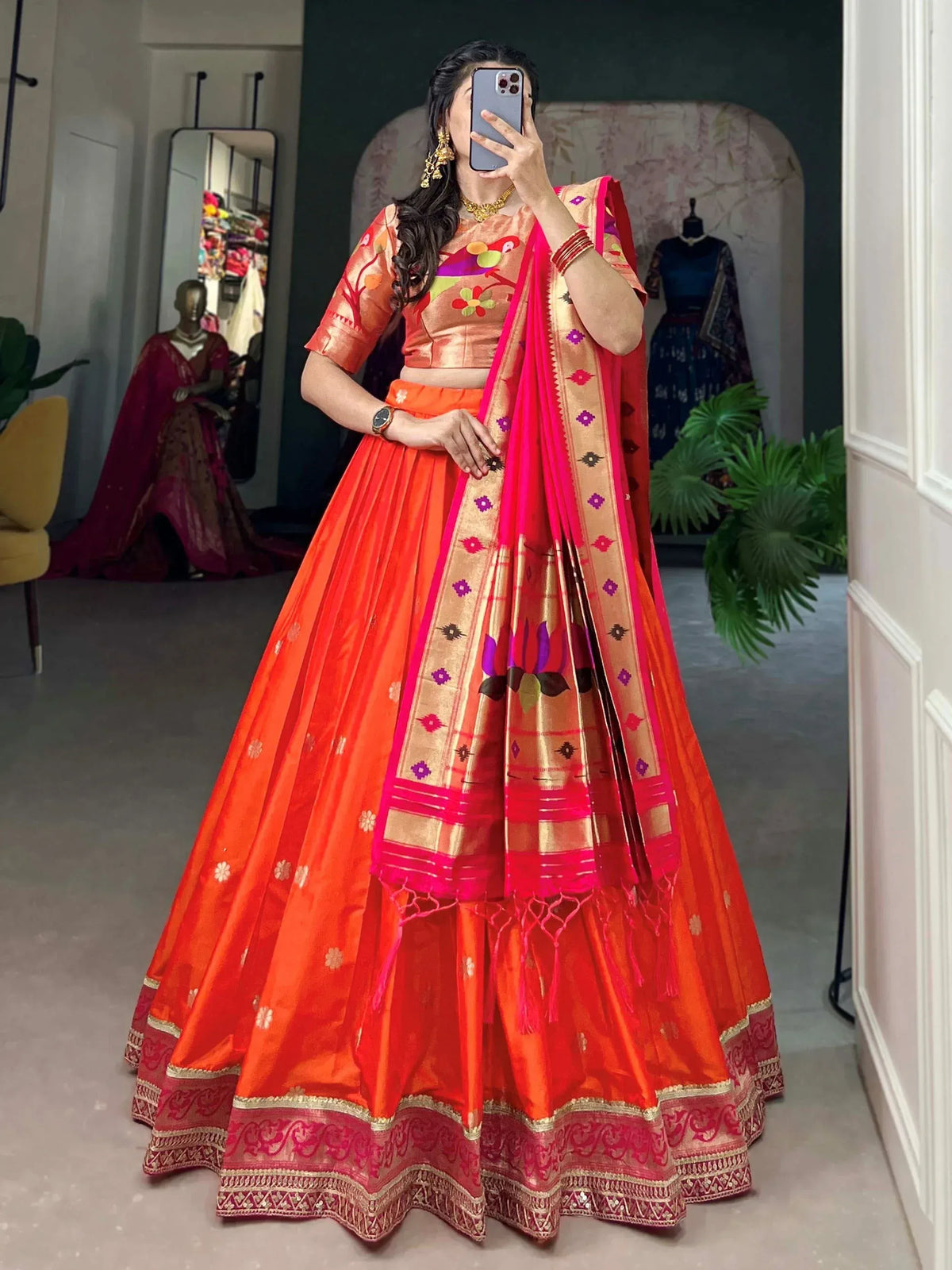 Vibrant orange lehenga choli with floral blouse and pink dupatta, perfect for Indian ethnic occasions