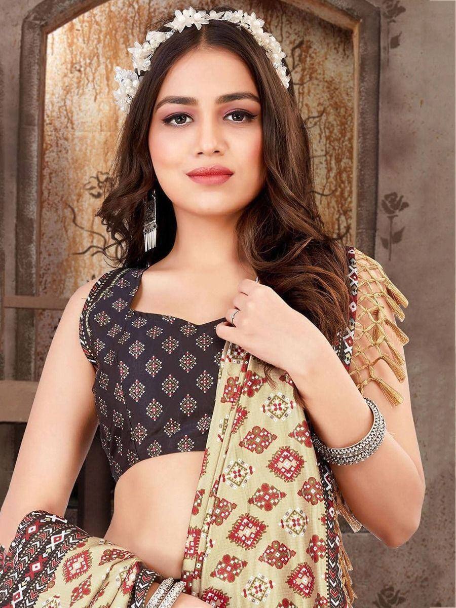 Woman in ethnic printed saree with black blouse, floral headpiece, and tassel dupatta