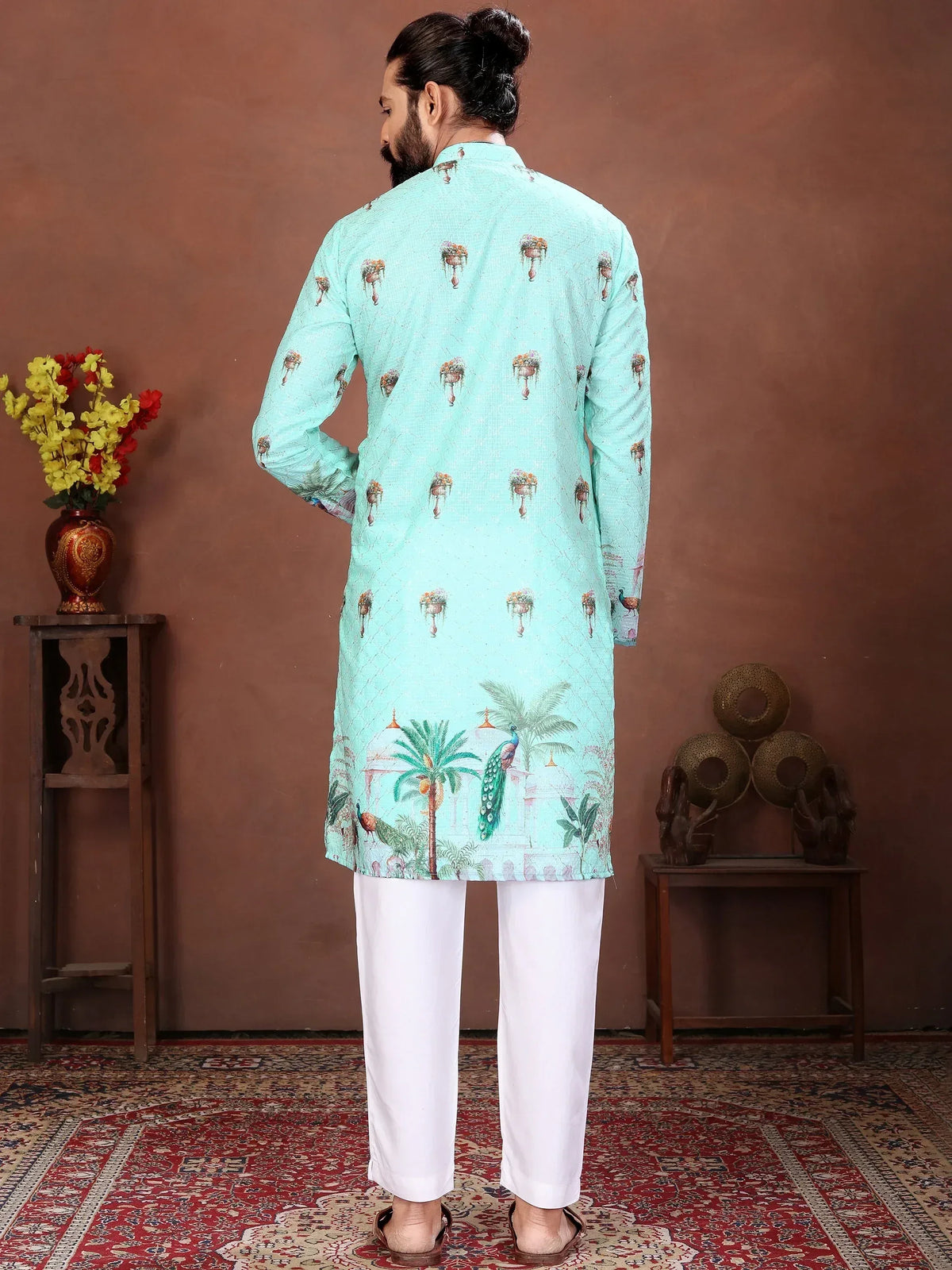 Back view of a man wearing a light blue printed ethnic kurta and white pajamas.